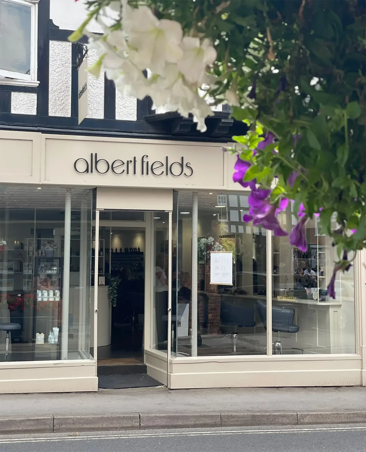 Front entrance of Albert Fields salon in Goring-on-Thames with hanging flower display.