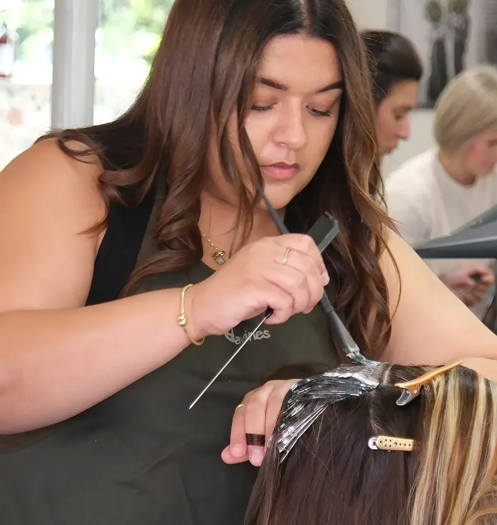 Close-up of a stylist applying highlights with foils at Albert Fields salon