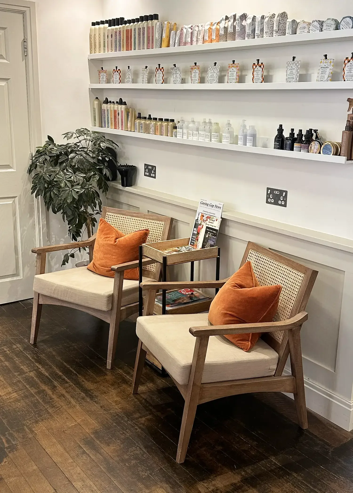 Albert Fields salon waiting area with modern chairs, orange cushions, and shelves of professional Davines haircare products