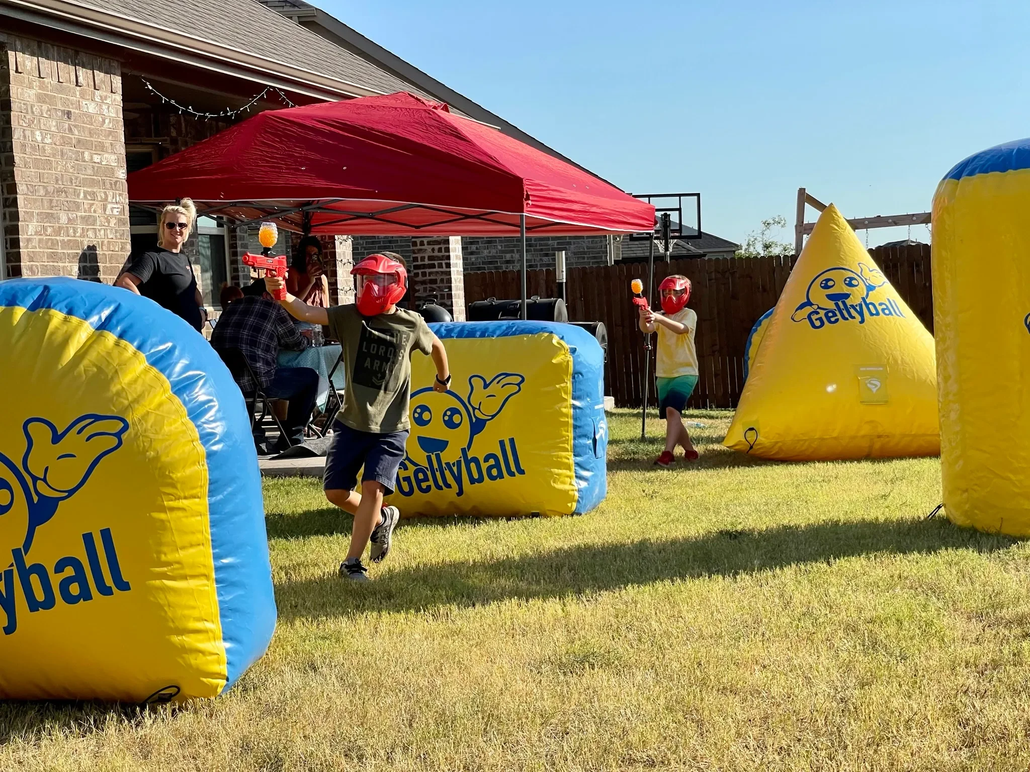Kids playing on inflatable Gellyball game in backyard.
