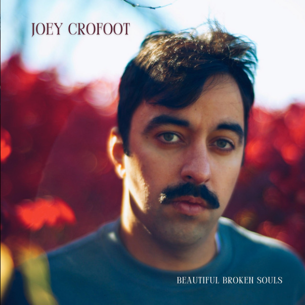 The album cover features a close-up photo of Joey Crofoot with a blurred red and purple background, displaying a serious expression, dark hair, and a mustache. The text includes his name at the top left and the album title "Beautiful Broken Souls" at the bottom right.
