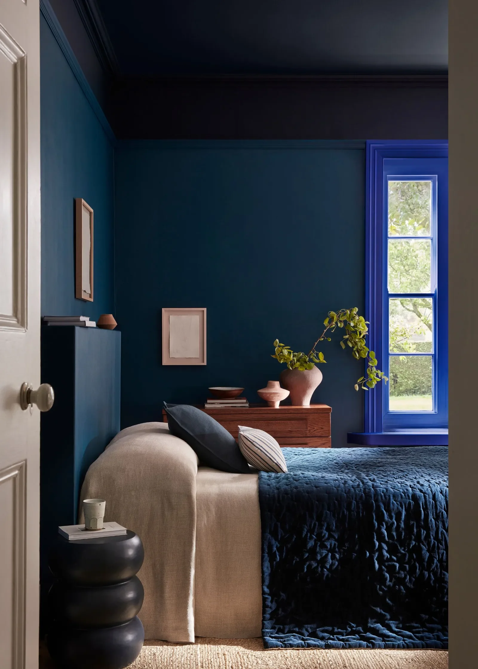 A cozy bedroom with dark blue walls
