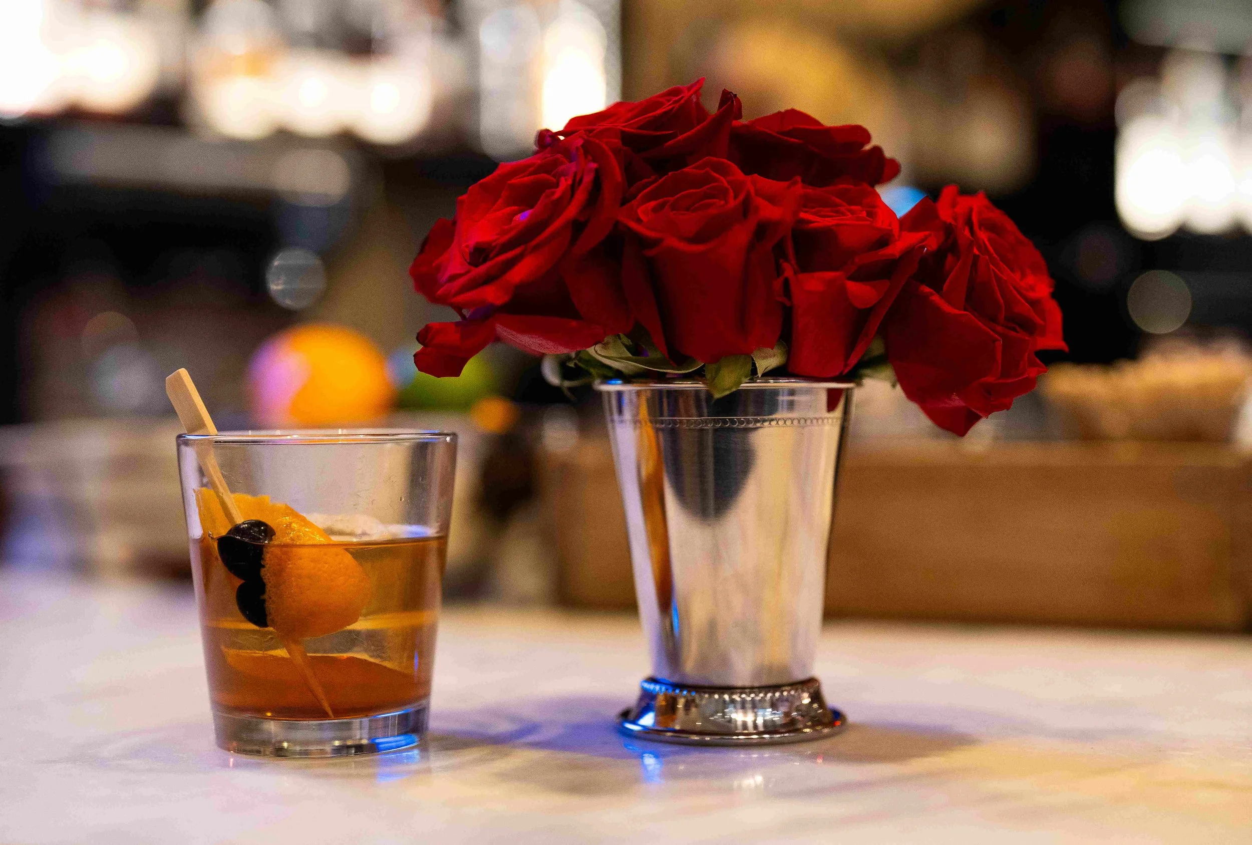 Red roses in a silver julep cup with an  Old Fashioned.