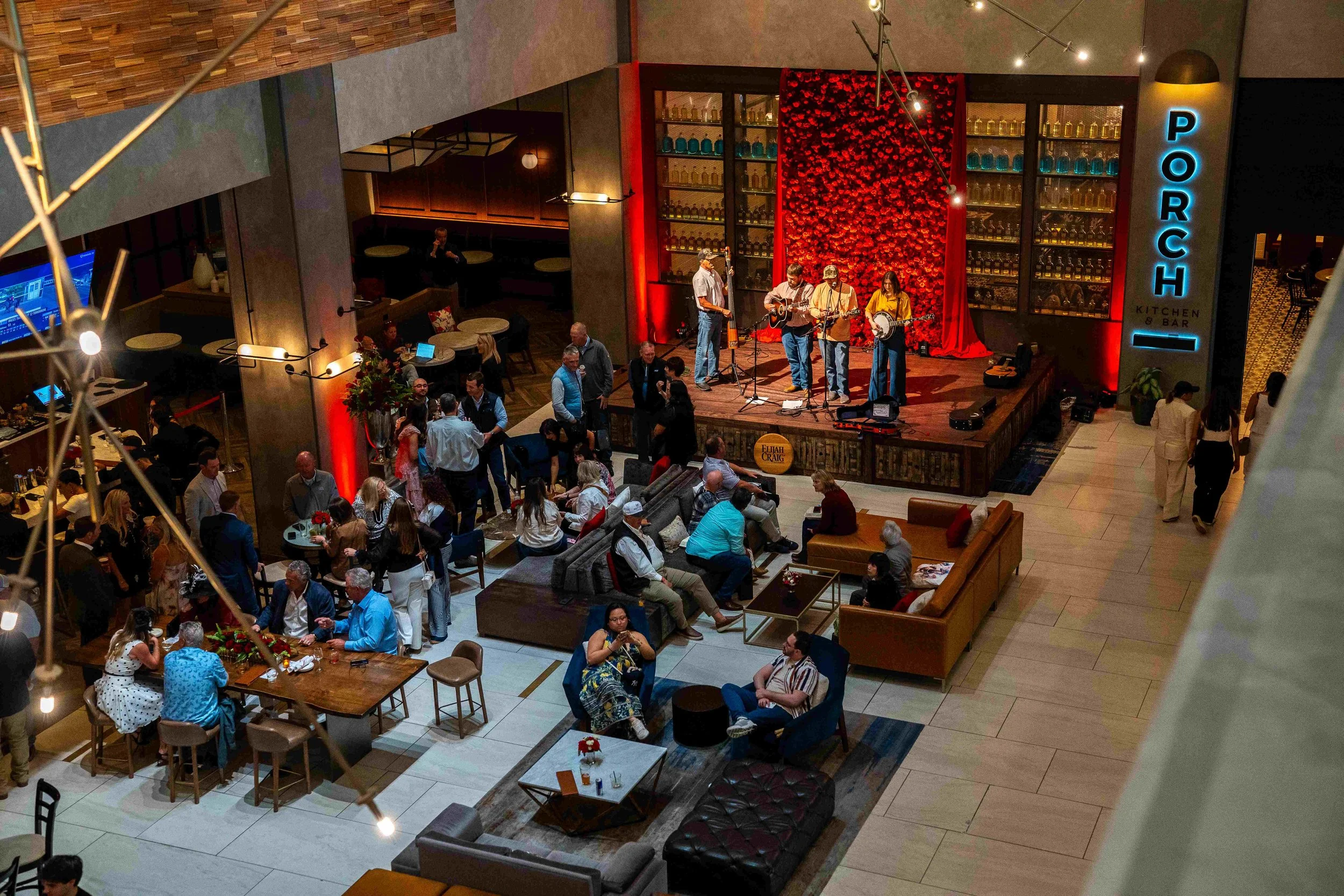People enjoying live music performance in a restaurant or bar with a stage, musical band, and various seating areas.