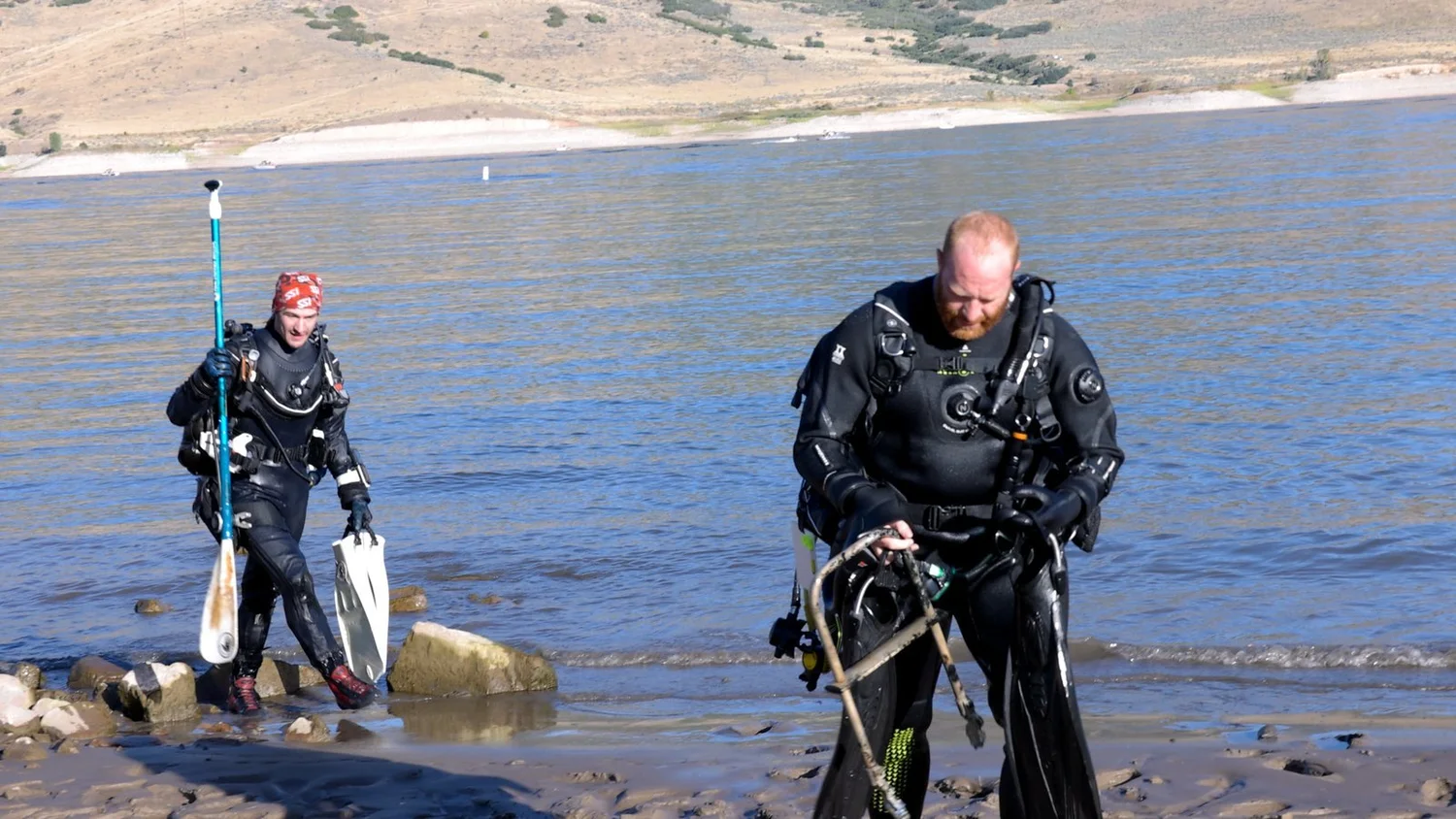 A Fathom diver carrying a rusted boat ladder out of Deer Creek Reservoir