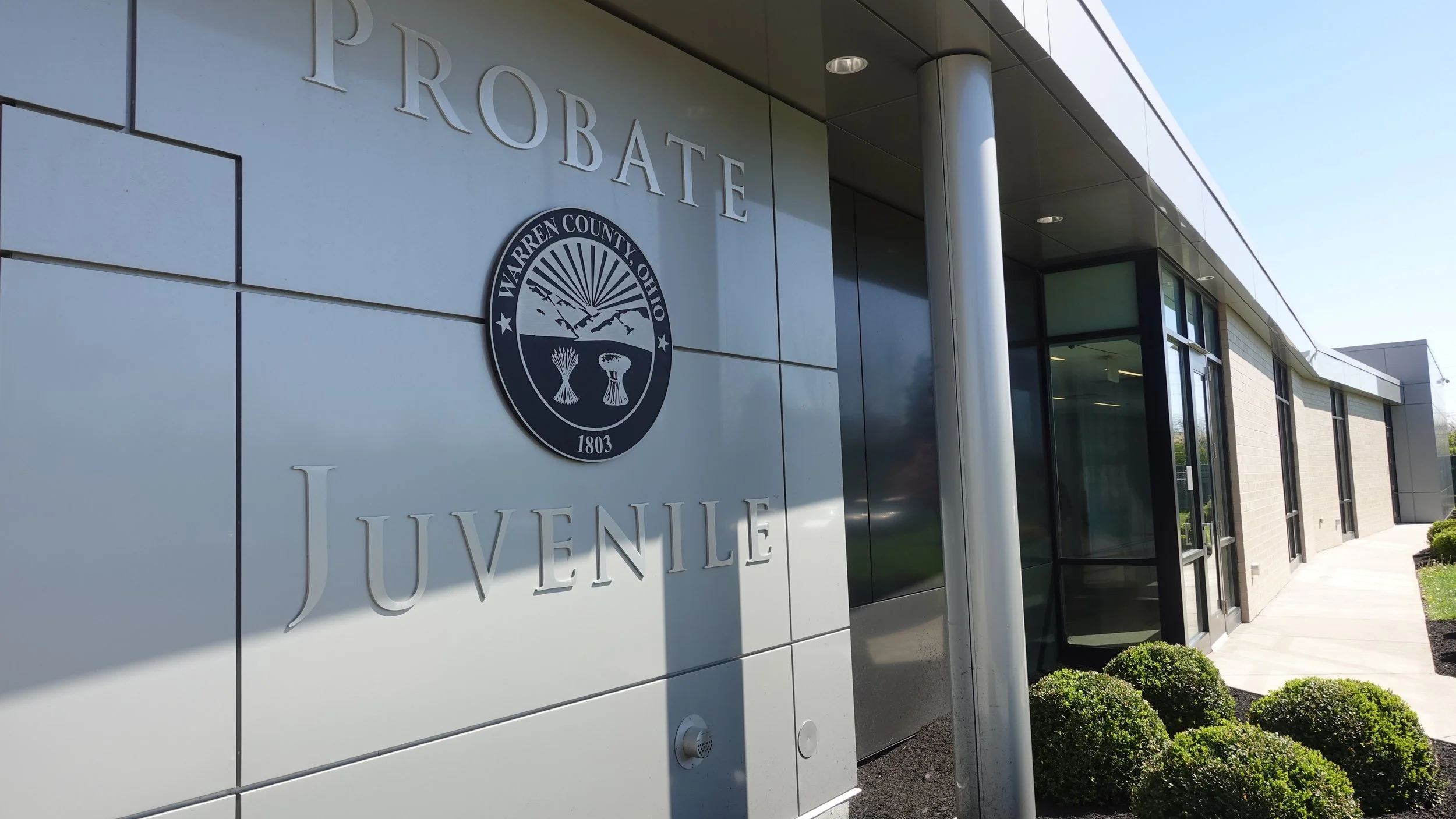 Exterior of a modern building with signage reading 'PROBATE' and 'YOUTH AND JUVENILE' with the Warren County, Ohio seal.