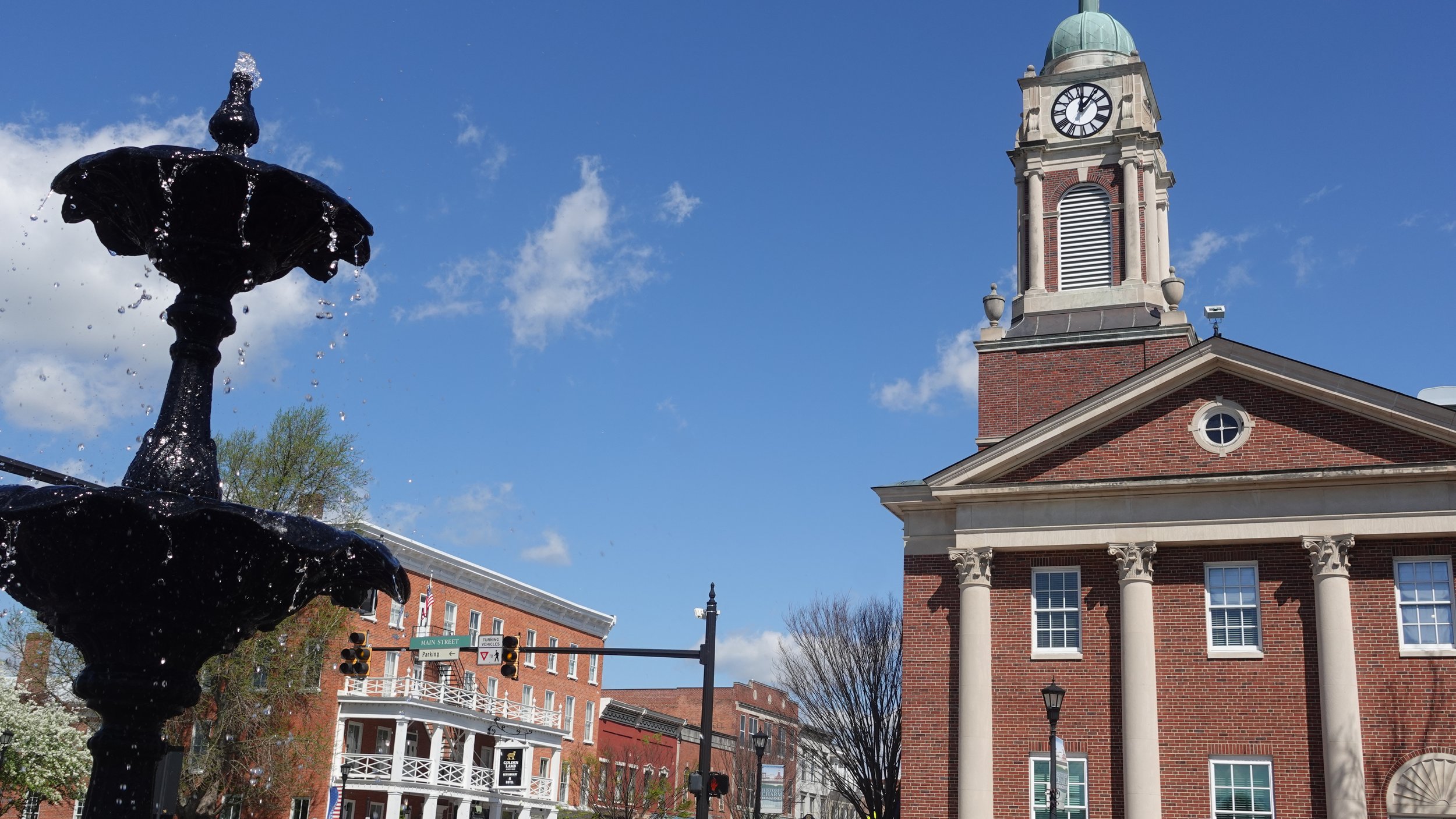 A water fountain and historic buildings during a sunny day.