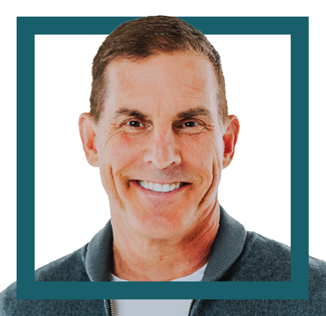 Smiling man with short brown hair wearing a dark gray zip-up sweater against a white background with a teal border.