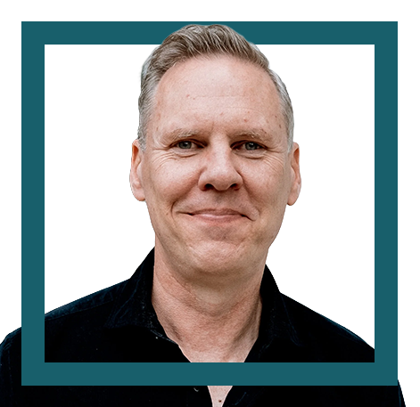 A headshot of a middle-aged man with short gray hair, smiling slightly, wearing a dark shirt, against a white background with a teal border.