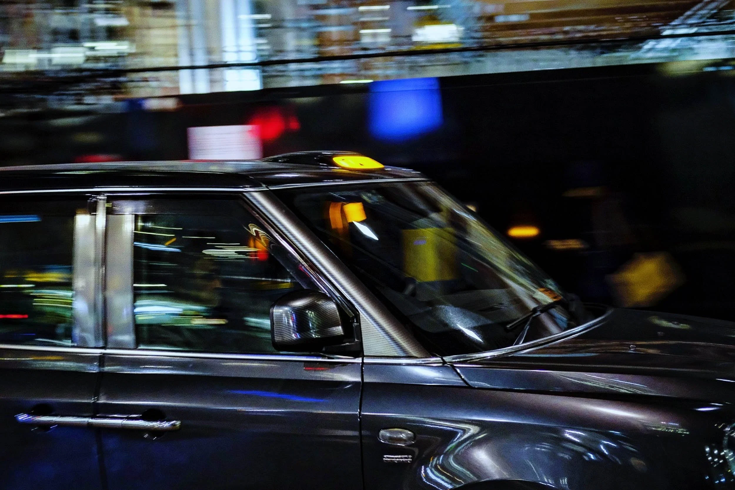 Motion blur with a London Black Cab at night in low light with motion blur