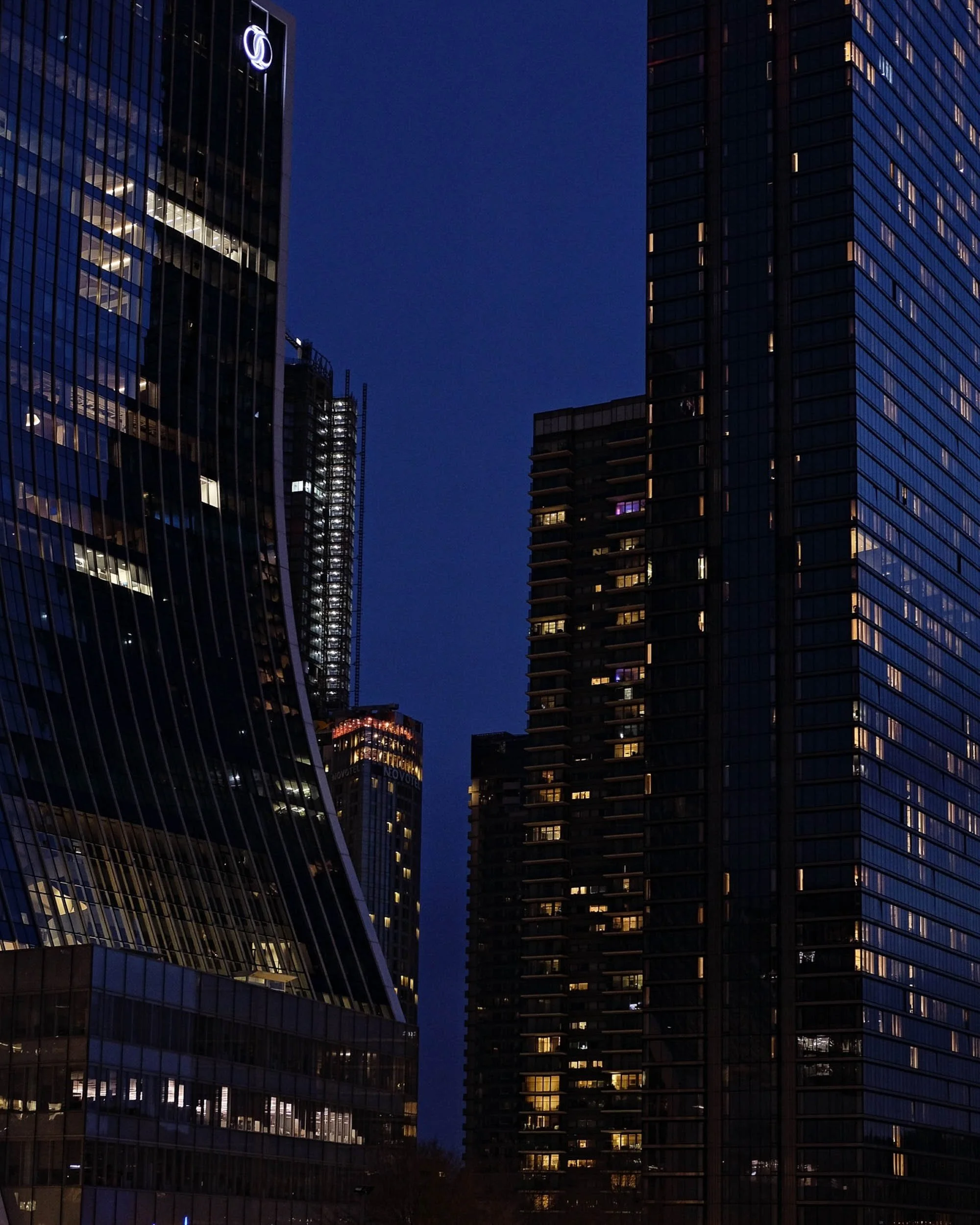 Canary Wharf at night with a midnight blue tone and warm orange and gold city lights