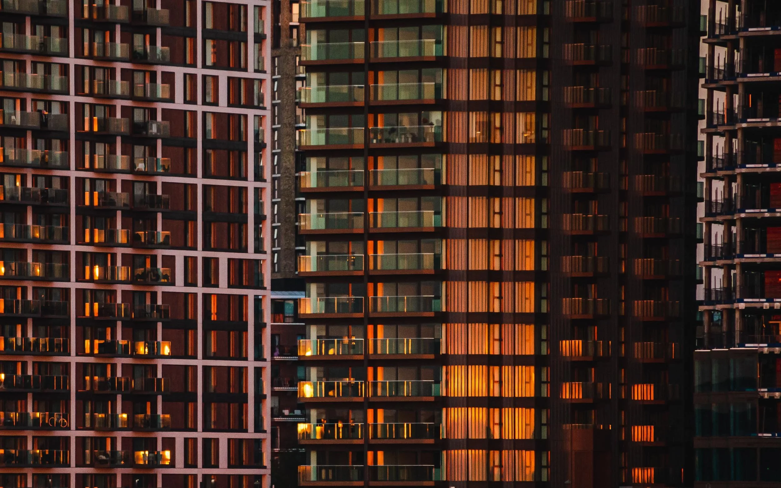 Complex view of new building developments south of the River Thames, Royal Docks, East London, E16, at Golden Hour, creates patchwork of bronze textures and reflections.