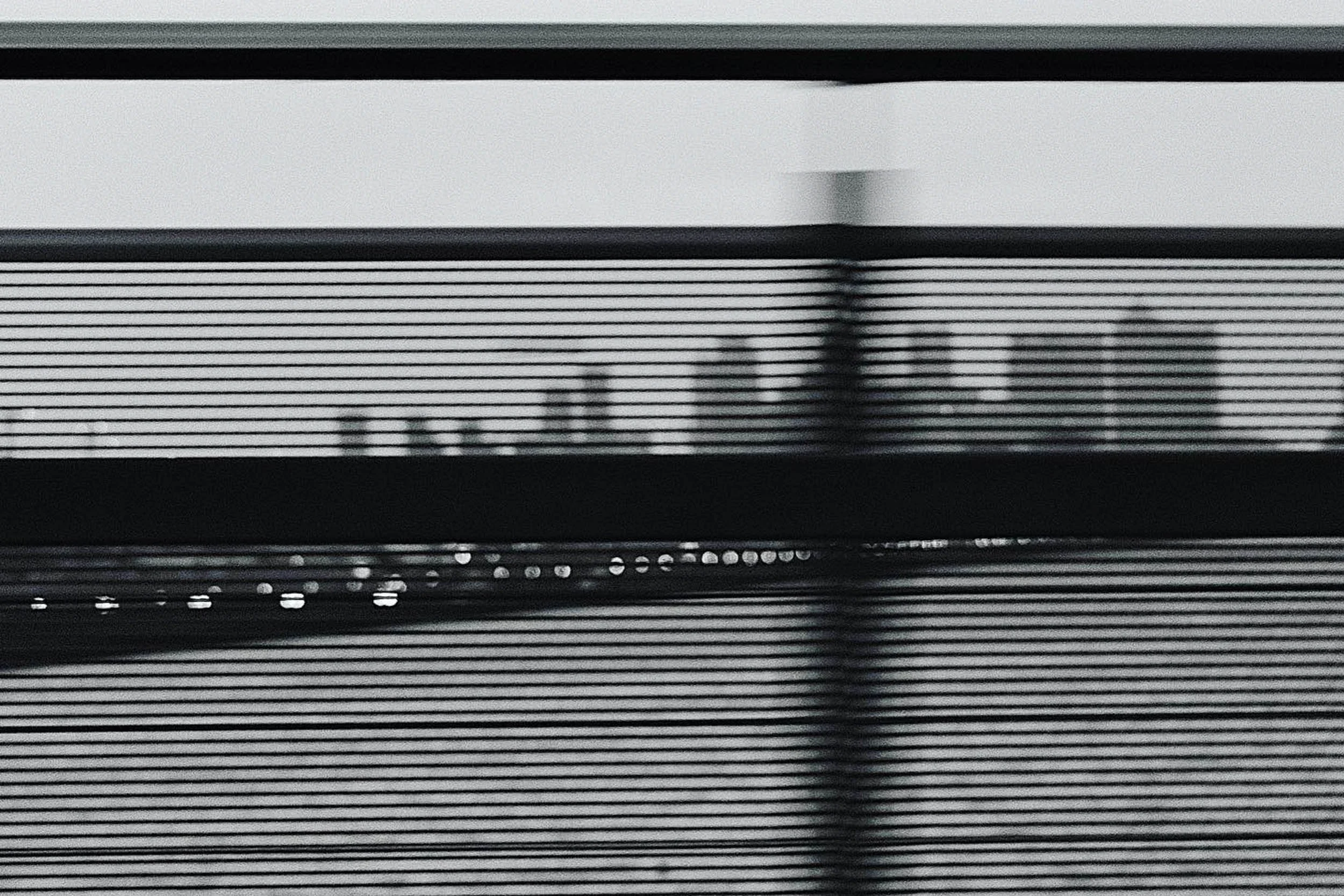 A grainy black and white image with motion blur in a Gotham city style view of Canary Wharf London over the docks