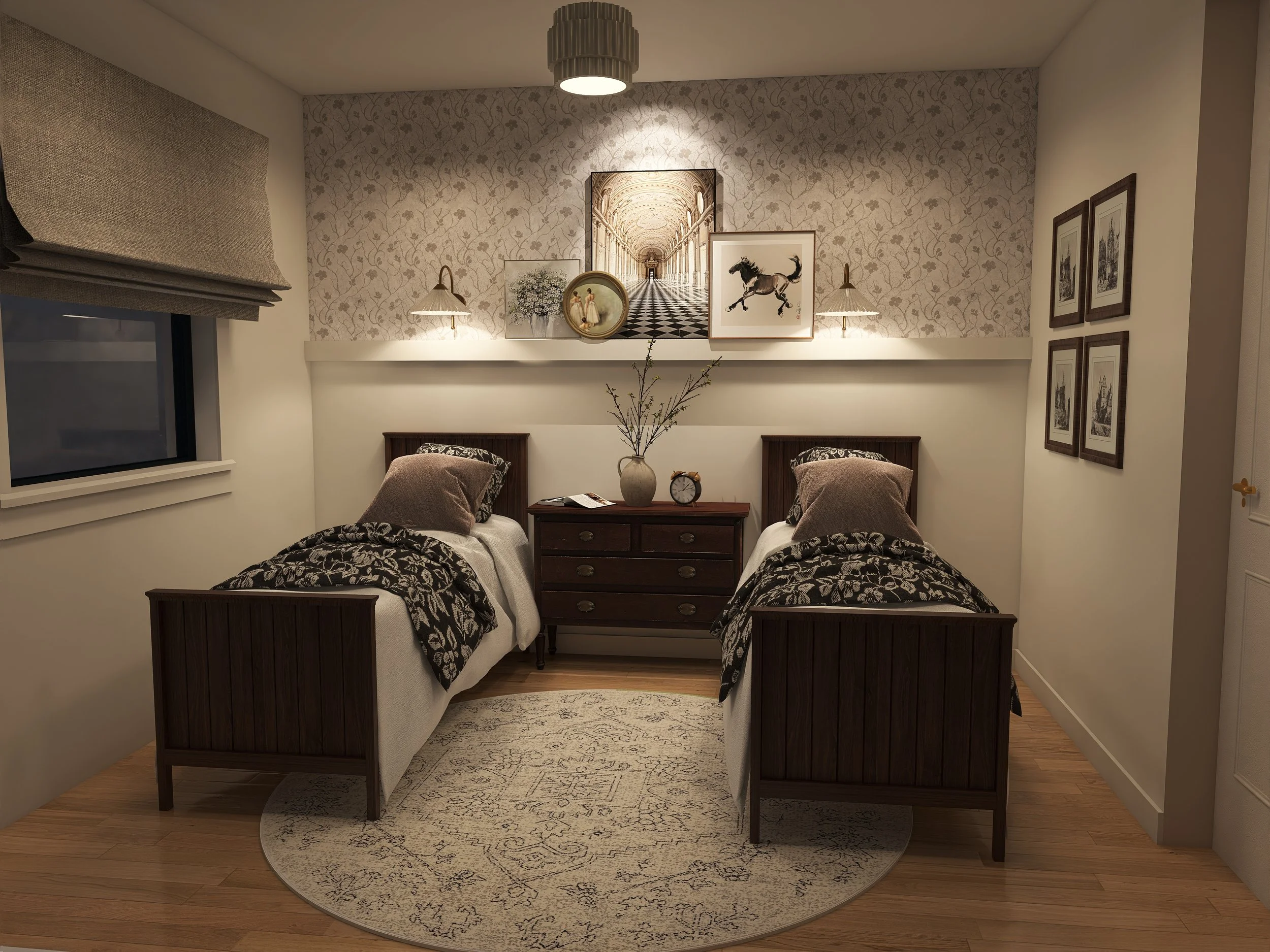 A cozy bedroom with two twin beds featuring dark wood headboards and patterned bedding. A white nightstand with a vase of branches, a clock, and a magazine is between the beds. The wall above displays framed artwork, including a large print of an ornate hallway, a painting of a horse, and smaller black-and-white prints. Two wall lamps illuminate the pictures. A window with a brown Roman shade is on the left, and a light-colored rug covers part of the wooden floor.