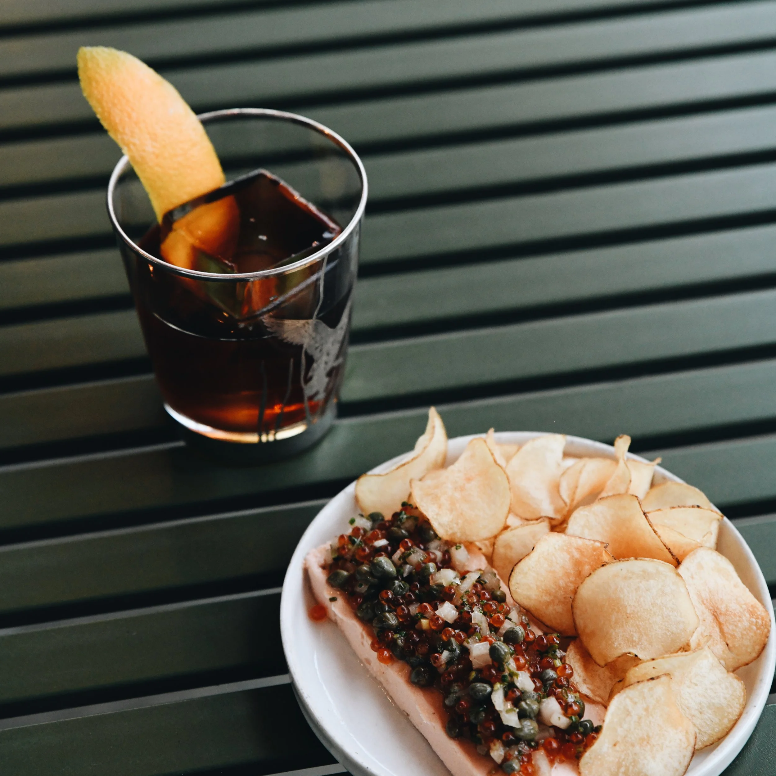 An image of a cocktail and appetizer