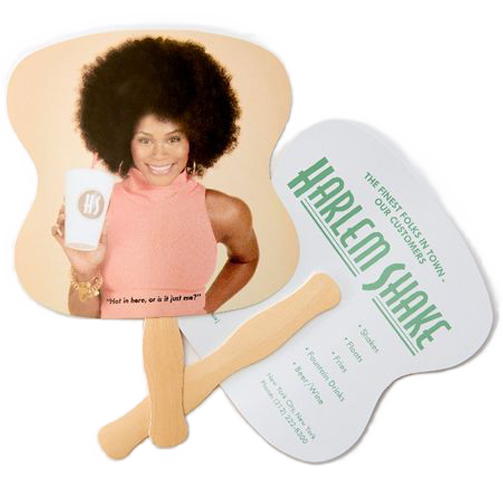A woman with a large afro hairstyle holding a mug with a logo, smiling, against a light background. Next to her is a promotional paddle with green text that reads "Harlem Shake" and additional text about the event.