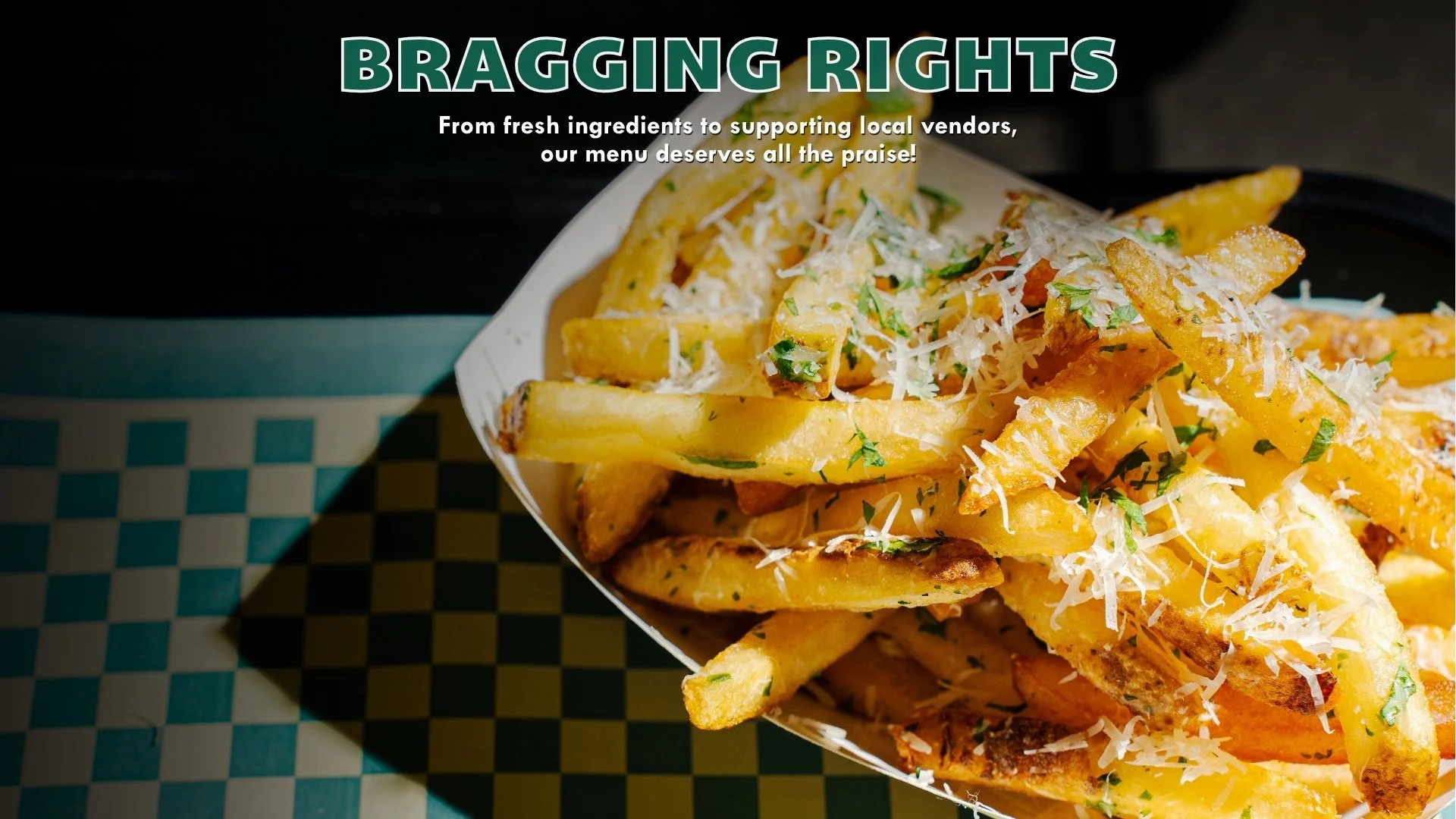 Close-up of loaded French fries topped with grated cheese and chopped parsley in a paper container.