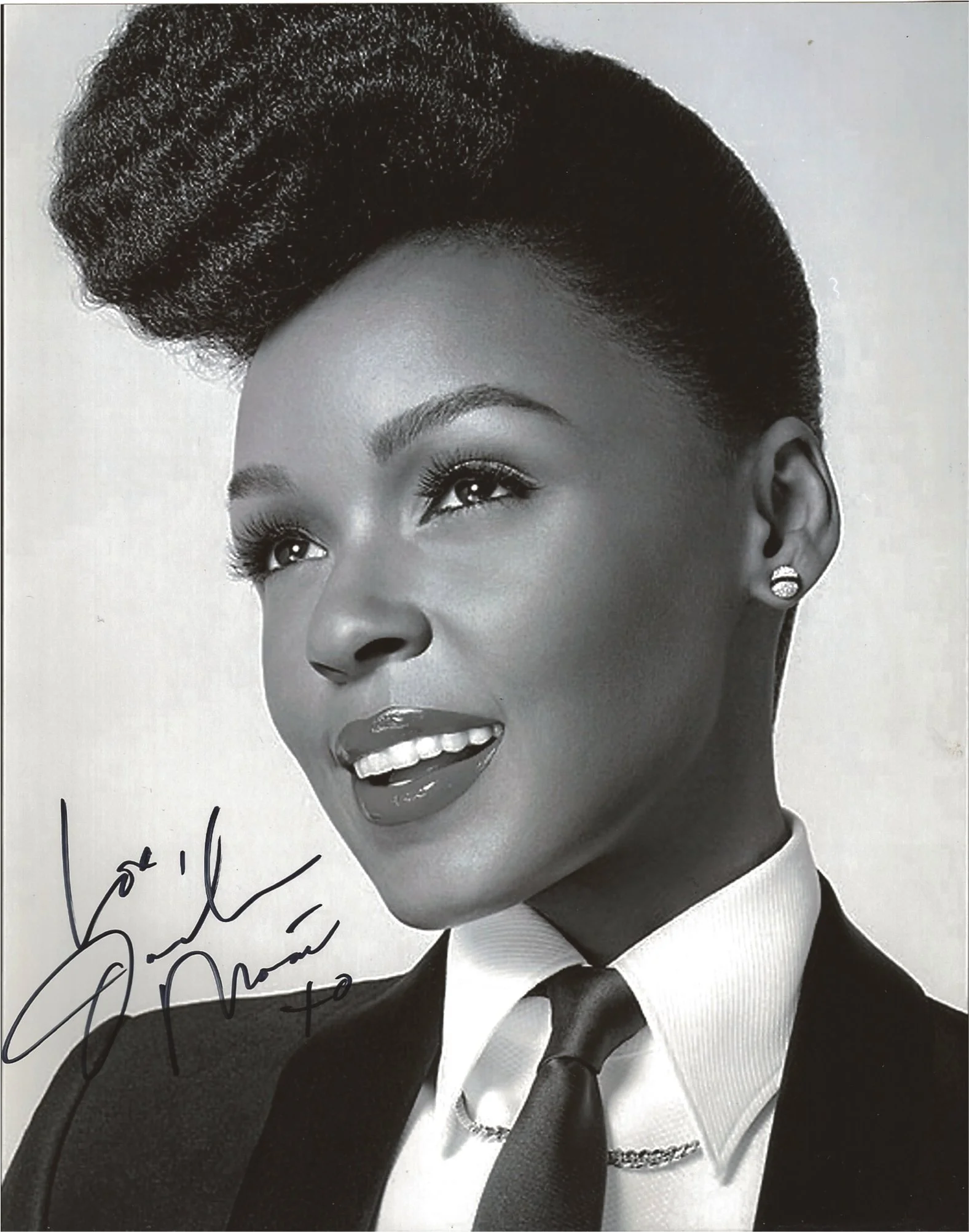 A black and white portrait of a woman with styled hair, wearing a suit and tie, with an earring, and with a signature partially visible at the bottom left corner.