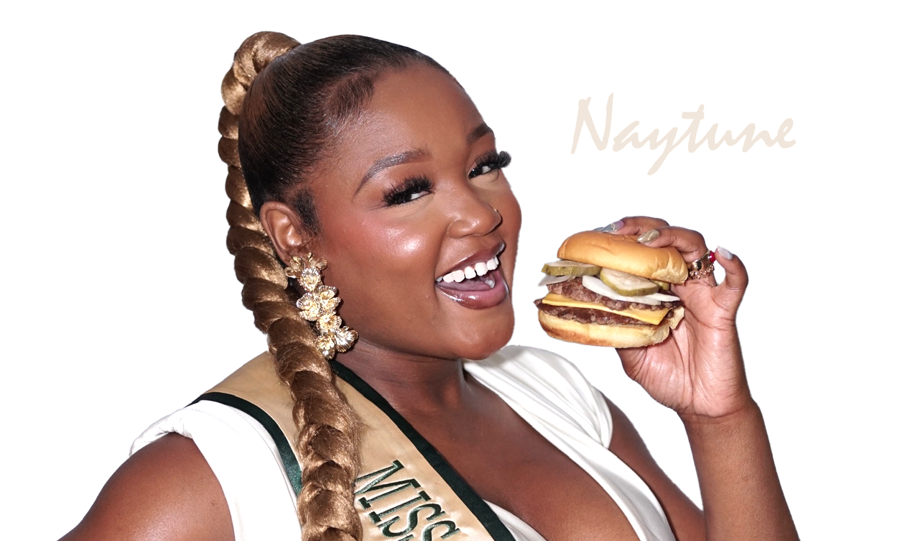 A woman with braided hair and floral earrings holding a cheeseburger.