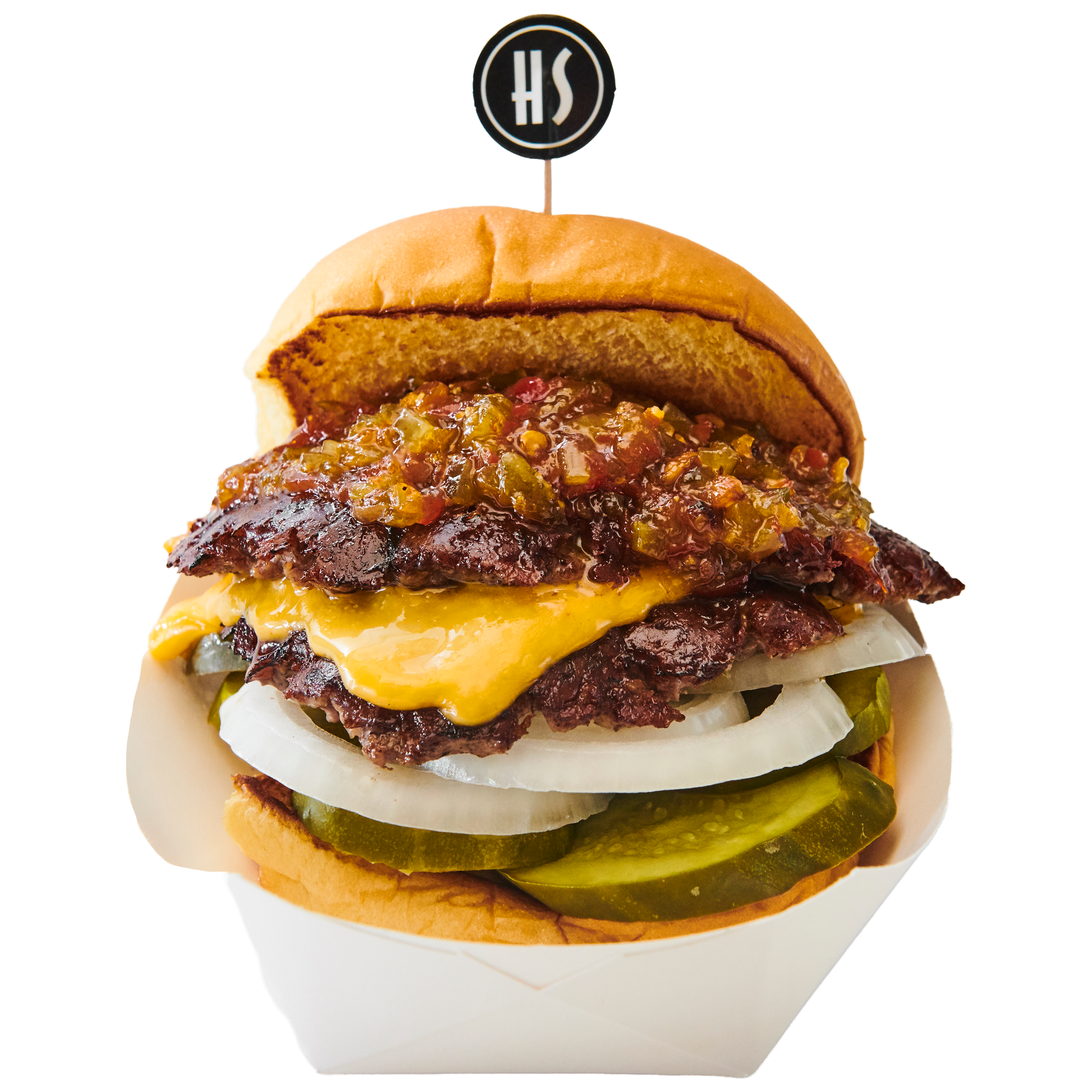 A burger with a sandwich bun, pickles, cheddar cheese, a beef patty, onions, barbecue sauce, and a top bun, topped with a flag labeled "HS."