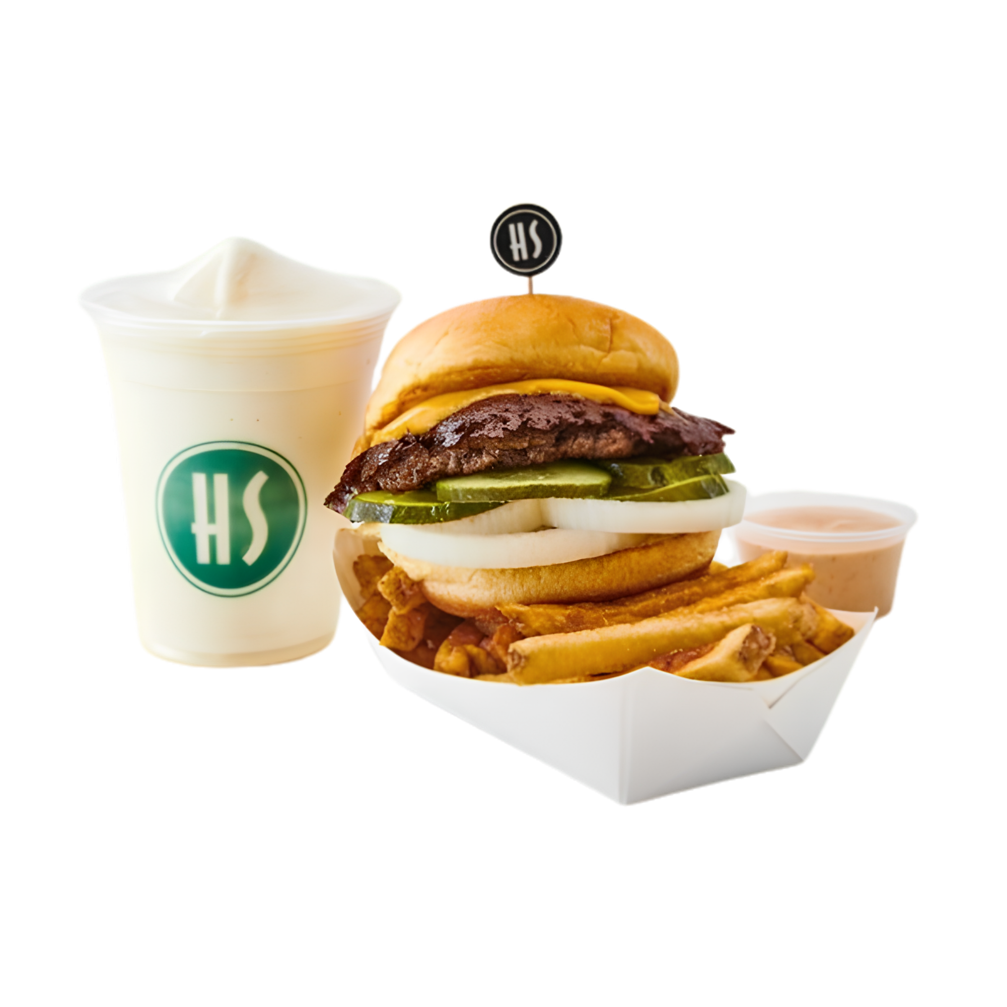 A cheeseburger with pickles, onions, and lettuce in a bun, accompanied by fries, a side of creamy sauce, and a drink with whipped cream.