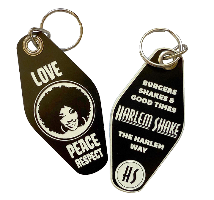 Two black keychains featuring white text and images. One with a smiling woman's face and words 'LOVE, PEACE, RESPECT,' and the other with words 'BURGER, SHAKES & GOOD TIMES, HARLEM SHAKE, THE HARLEM WAY, HS'.