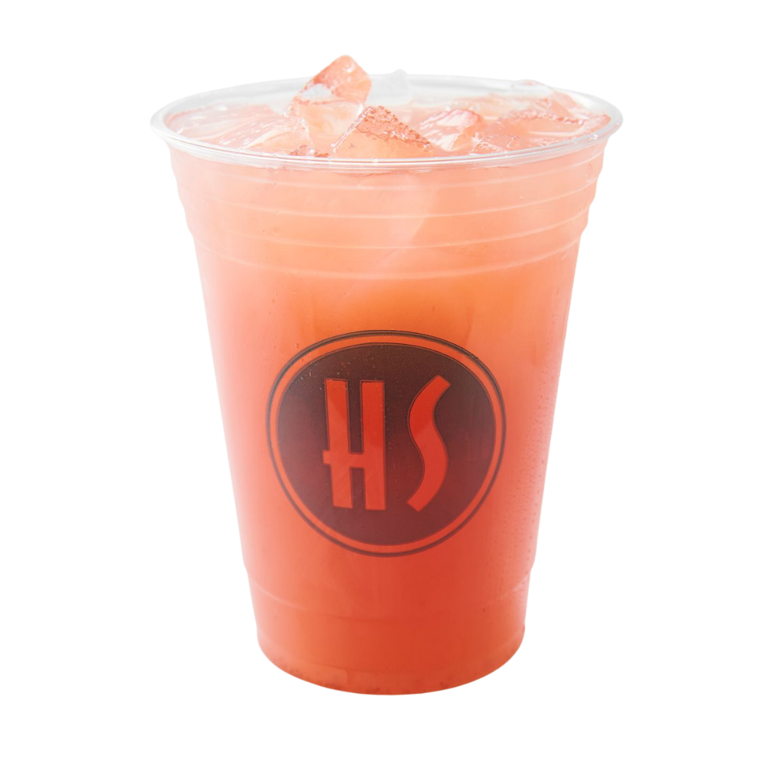 A clear plastic cup filled with pink grapefruit juice and ice, featuring a black logo with red letters 'HS' on the front.