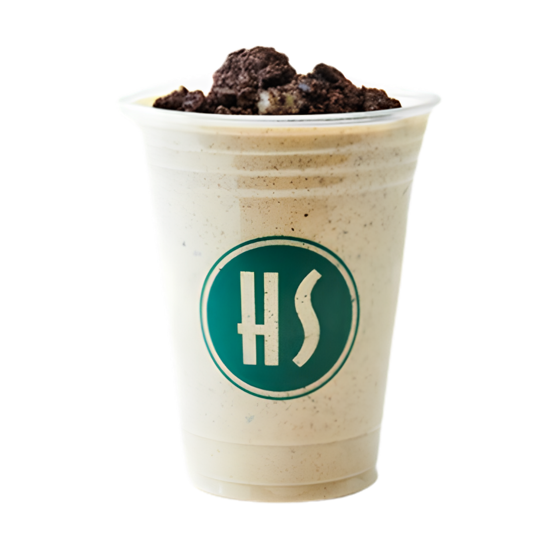 A Starbucks frappuccino-style beverage topped with crumbled cookie or brownie pieces, served in a tall clear plastic cup with the Starbucks logo.