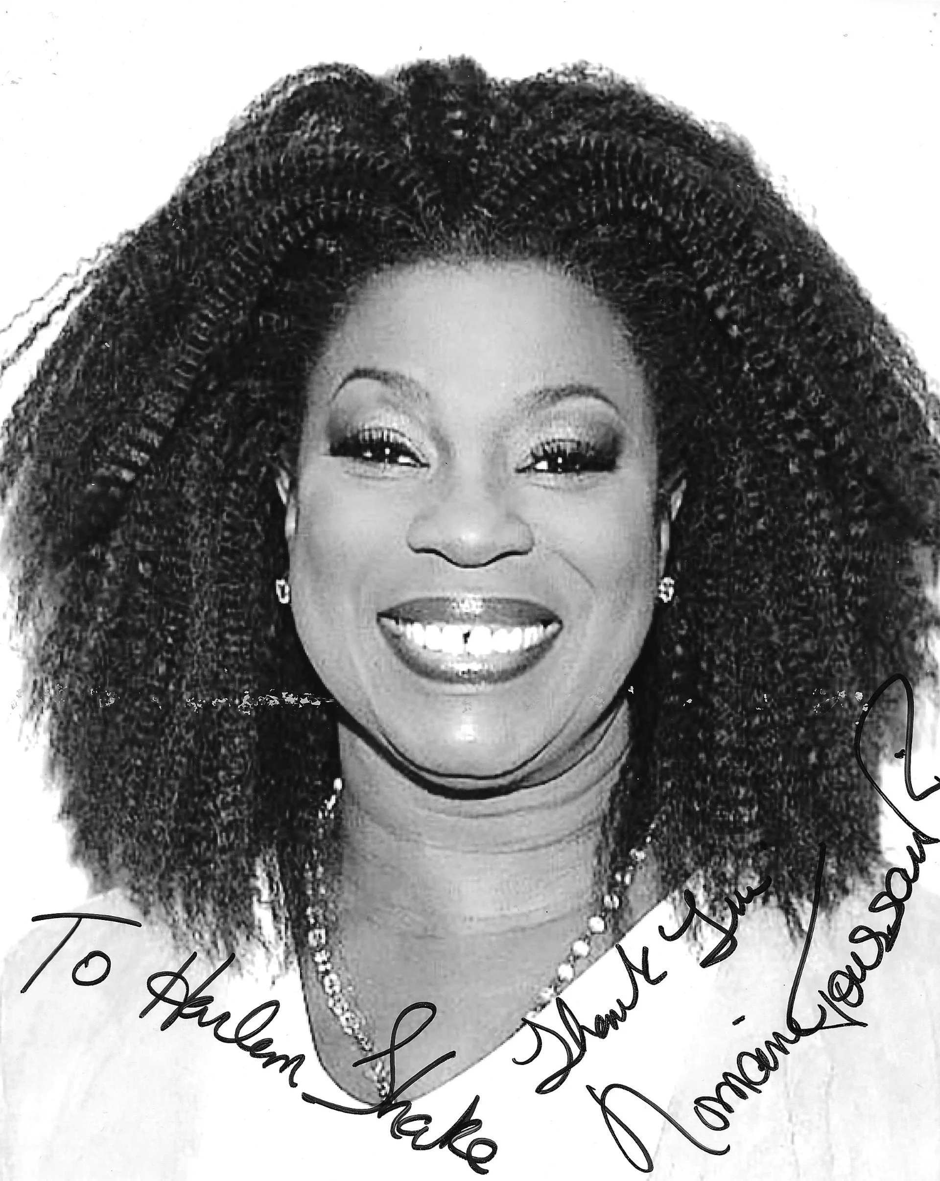 Black and white photo of a smiling woman wearing jewelry, with handwritten notes around her.