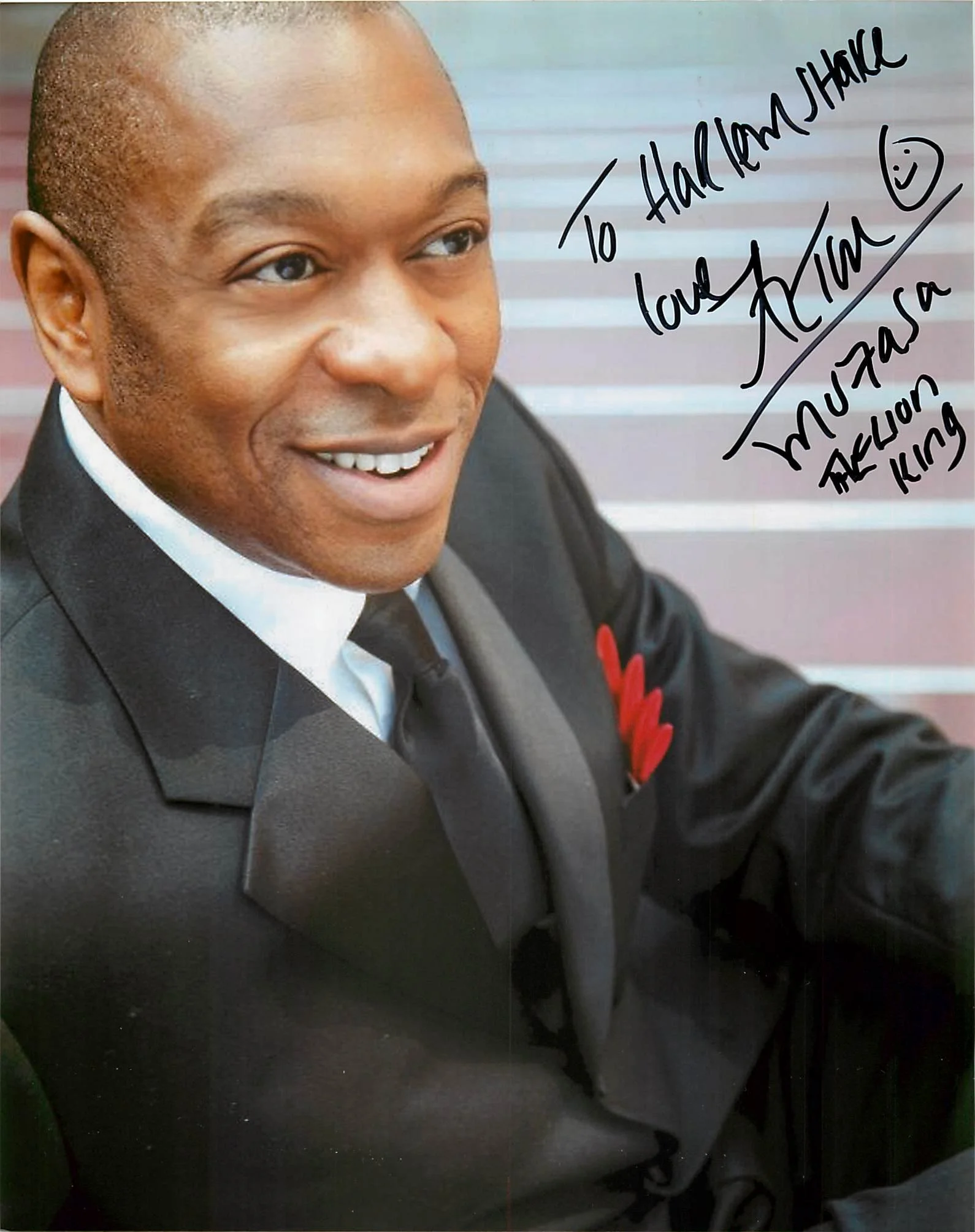 A man in a suit smiling, with handwritten note on the image that says: "To Harold Uhaike, Love, Alan Kim, August 25, 2023, The King" with a smiley face.