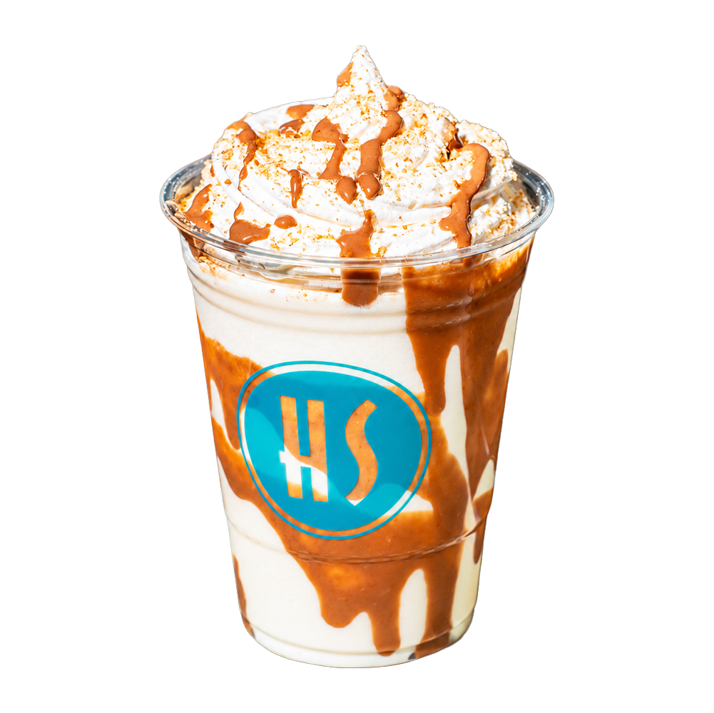 A caramel frappuccino with whipped cream and caramel drizzle in a plastic cup with a blue logo.