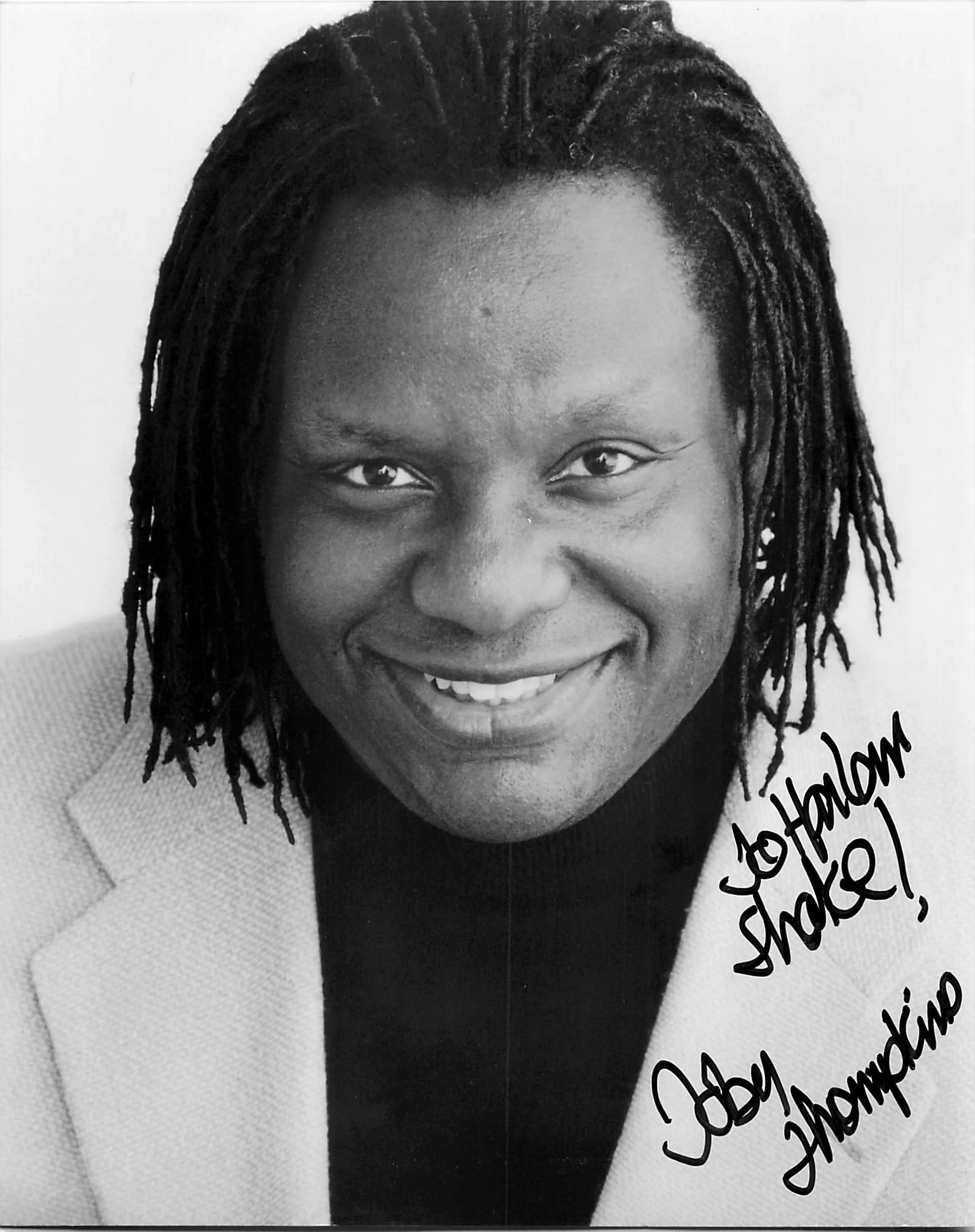 Black and white portrait of a smiling woman with dreadlocks, partially visible text on the right side reading "Congratulations".