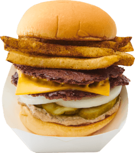 A cheeseburger with bacon, onion rings, pickles, cheese, and various meats in a bun.