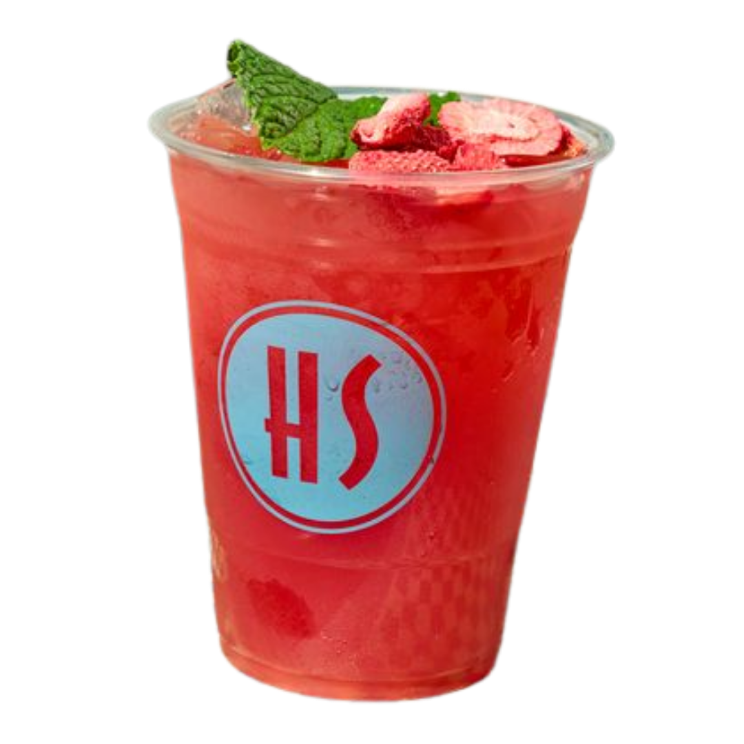 A clear plastic cup filled with a red beverage, garnished with mint leaves and pink fruit slices, with a blue and red logo on the front.