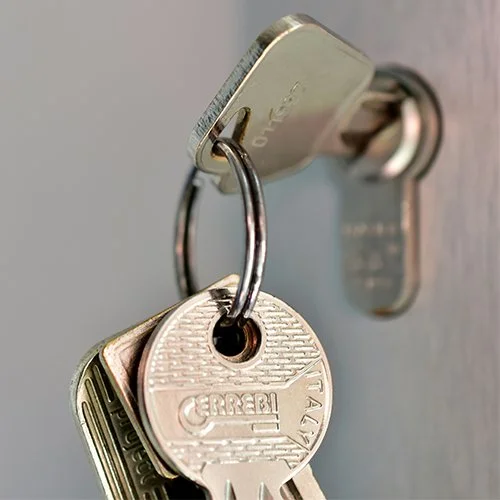 Keys hanging on a keyring inserted into a door lock.