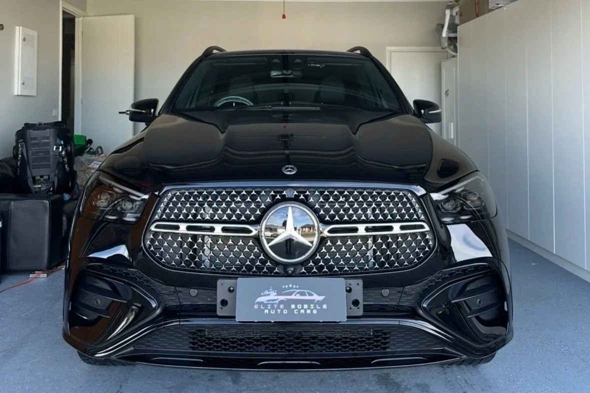 On-site mobile car detailing of a black Mercedes Benz SUV inside a client's garage in Melbourne