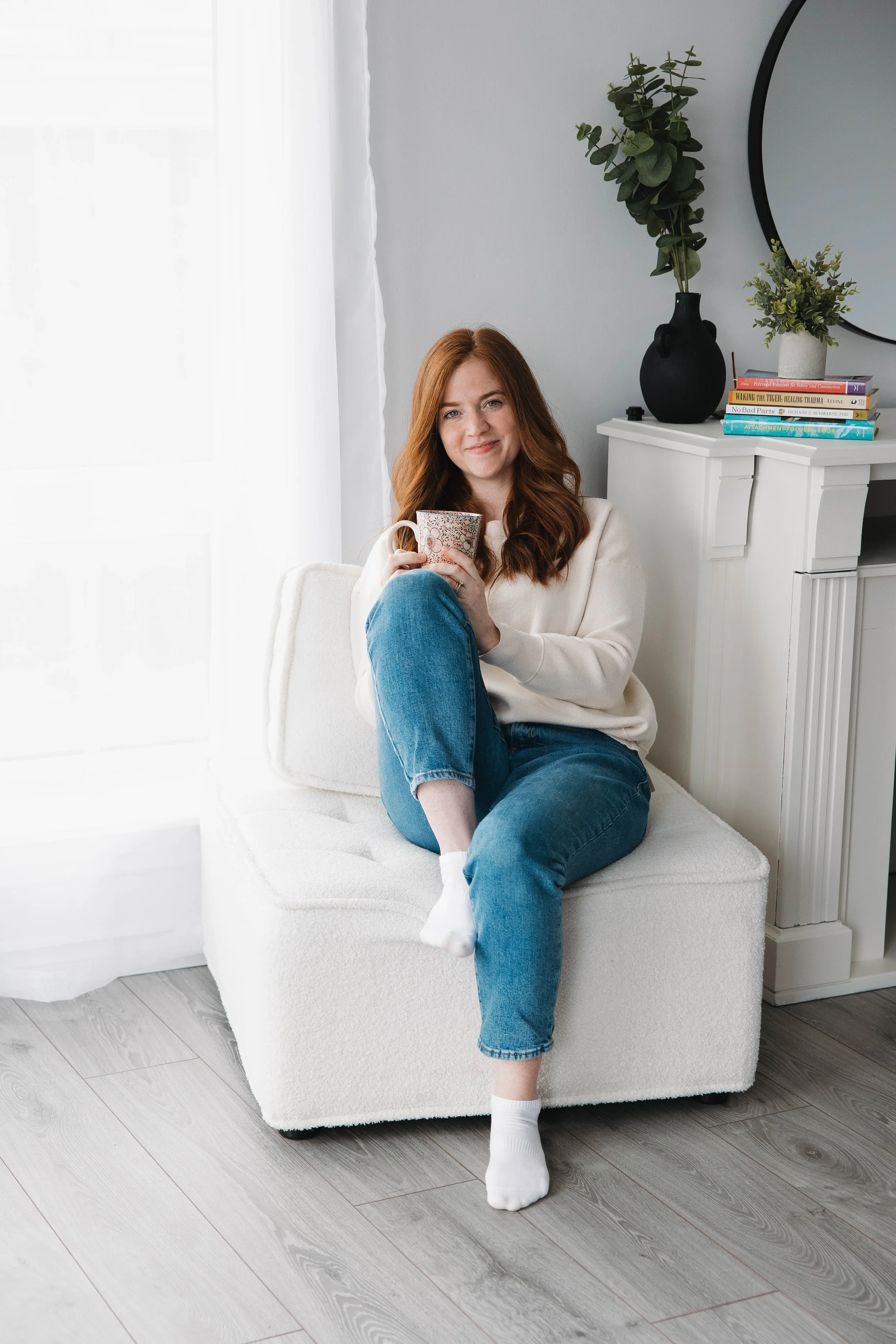 A woman sitting in a chair holding a mug.