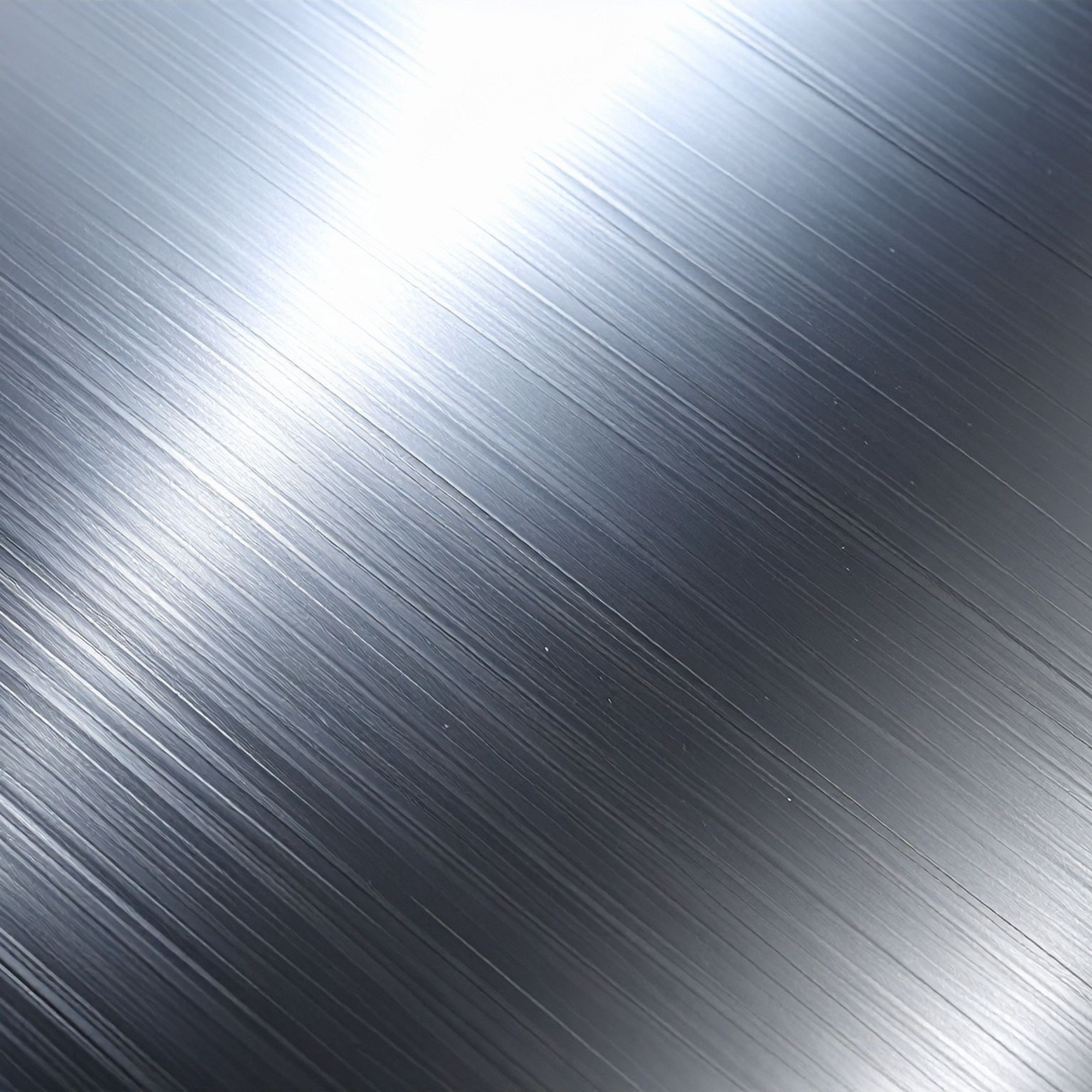 Close-up of a metallic surface with visible brushed texture and a bright light reflection.