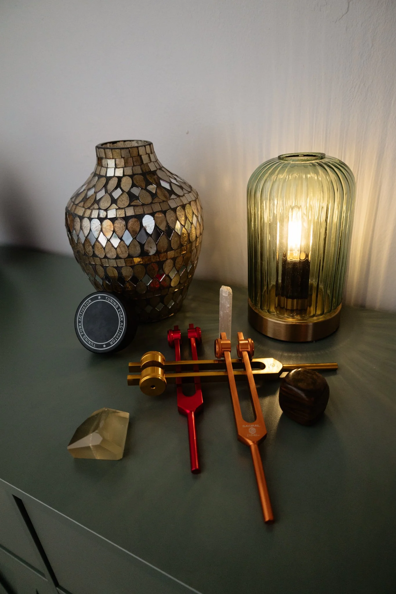 Decorative lamps, jewelry tools, and gemstones on a table.