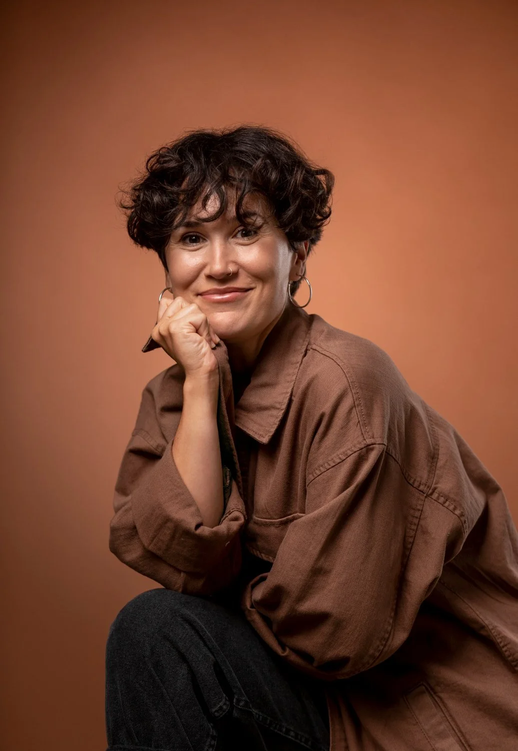 Woman smiling warmly against a natural background — reflecting the connection and trust built in therapy in Ogden, Utah