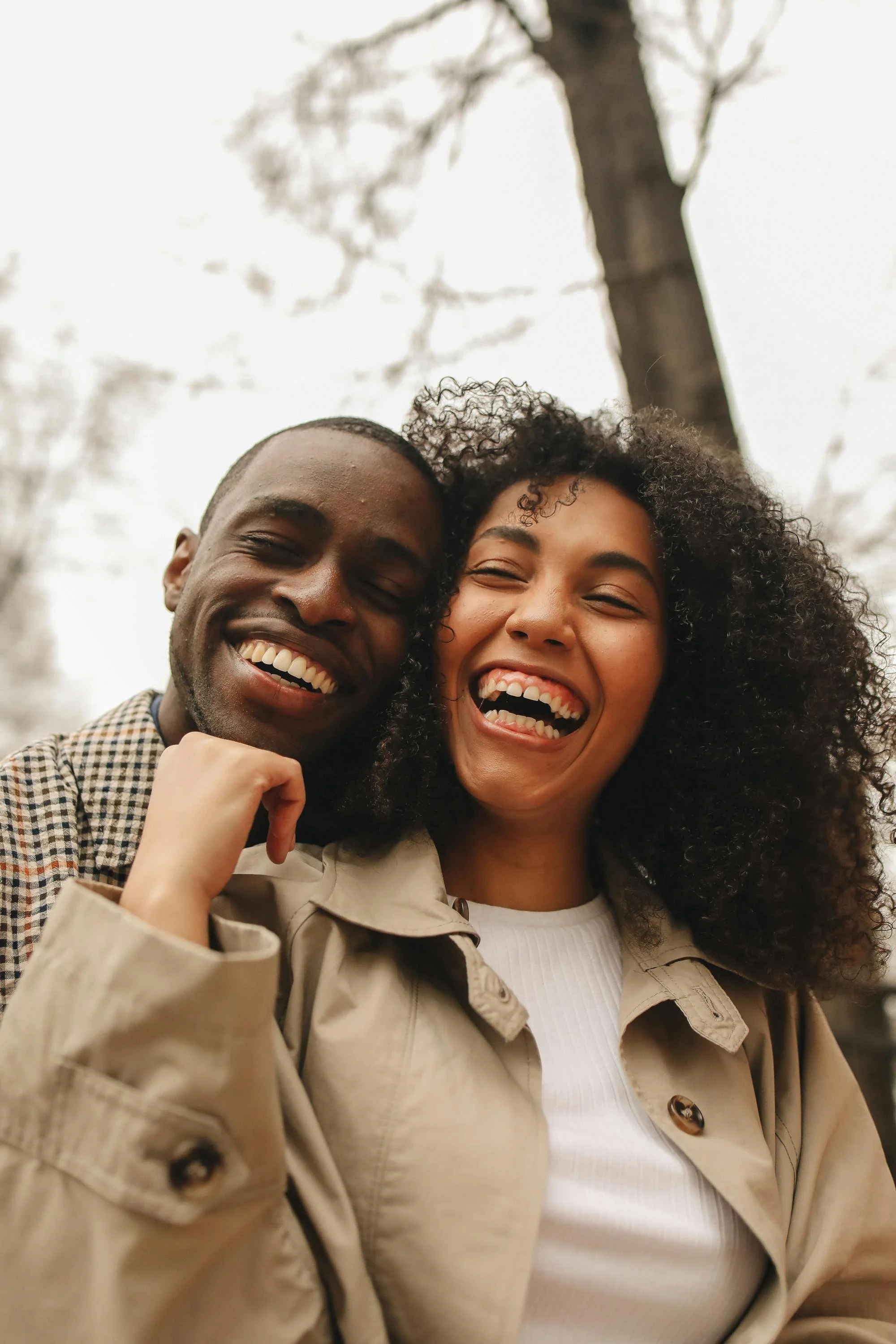 Smiling couple close together outdoors — representing connection and hope through couples therapy and marriage counseling in Ogden, Utah