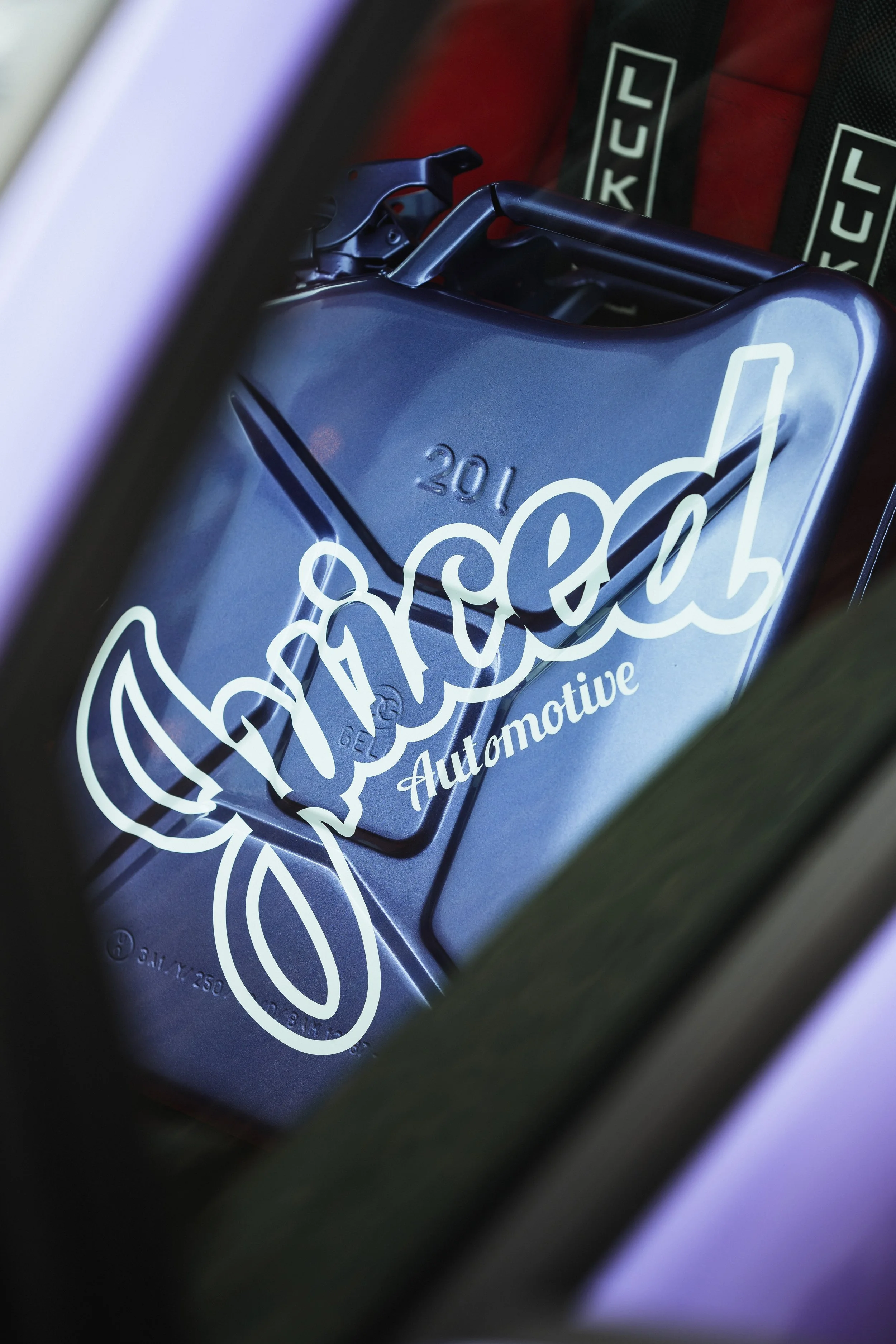 Close-up of a metallic object with the text '201' and some graphic elements, in a dark setting with red lighting in the background.