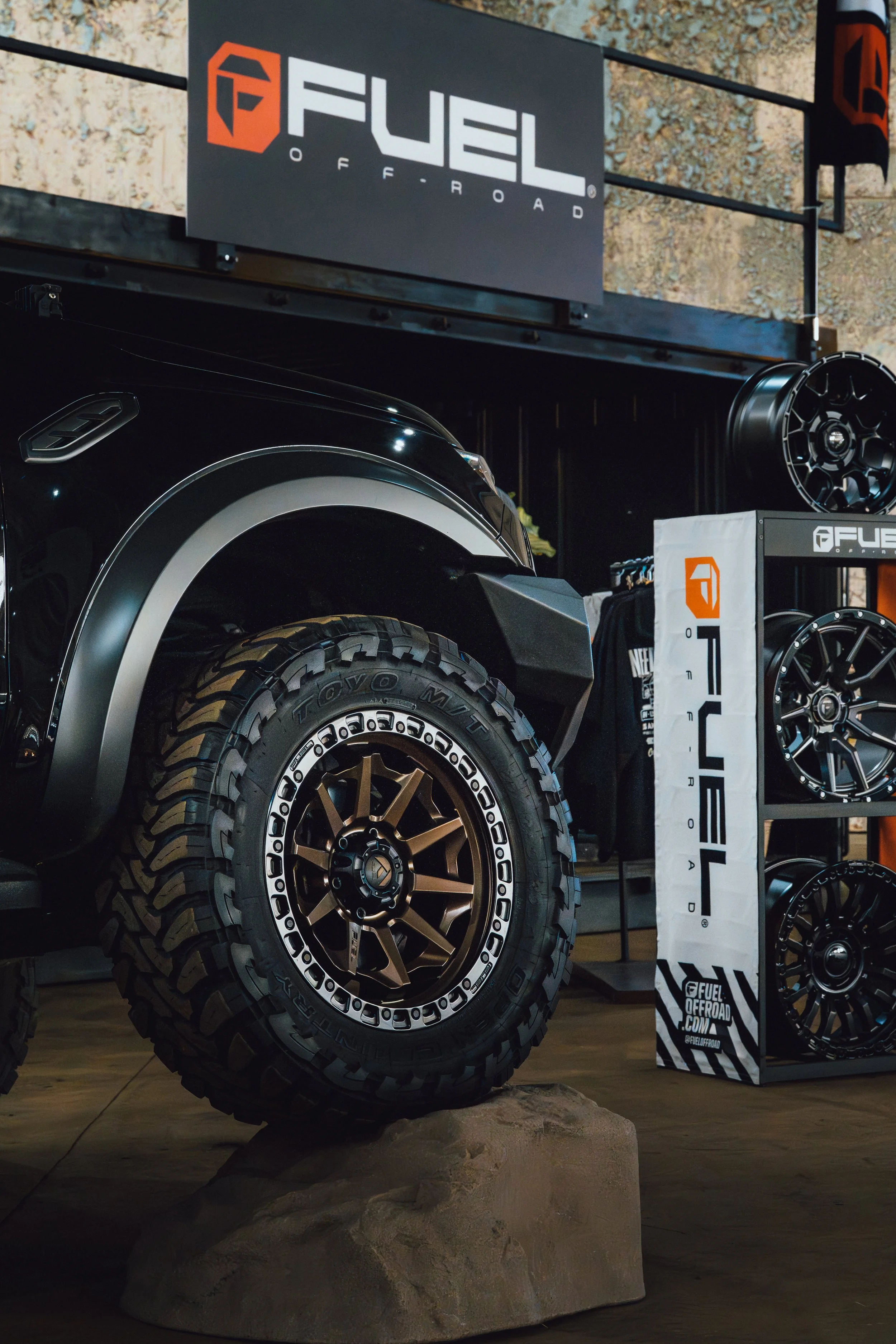 Display of off-road vehicle tires and wheels at a trade show with Fuel Off-Road branding.