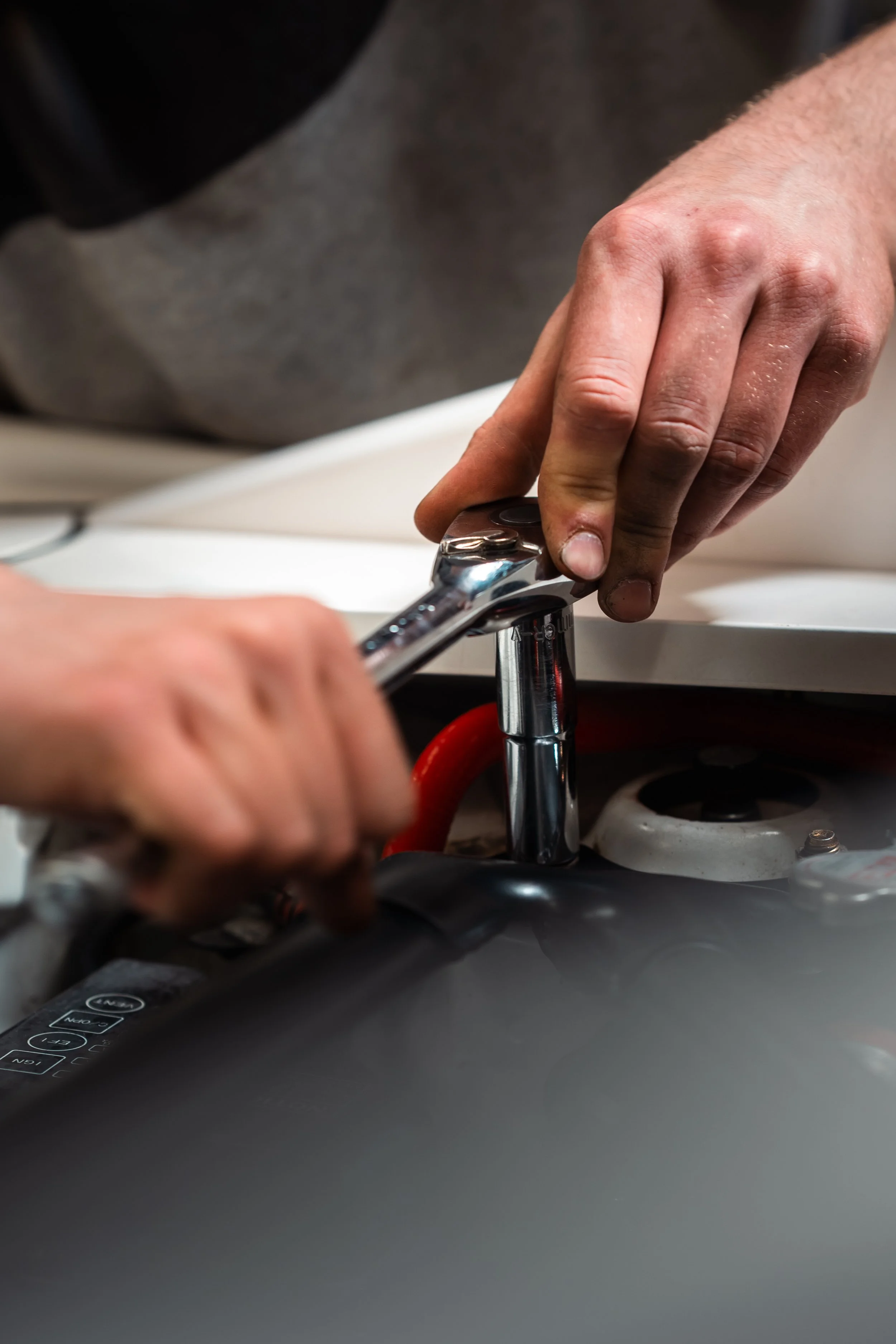 A person's hand turning on a kitchen sink faucet.