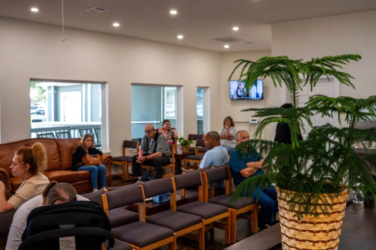 Image shows the waiting room of Mahaffey Family Medicine. Patients can be seen waiting for their appointments.
