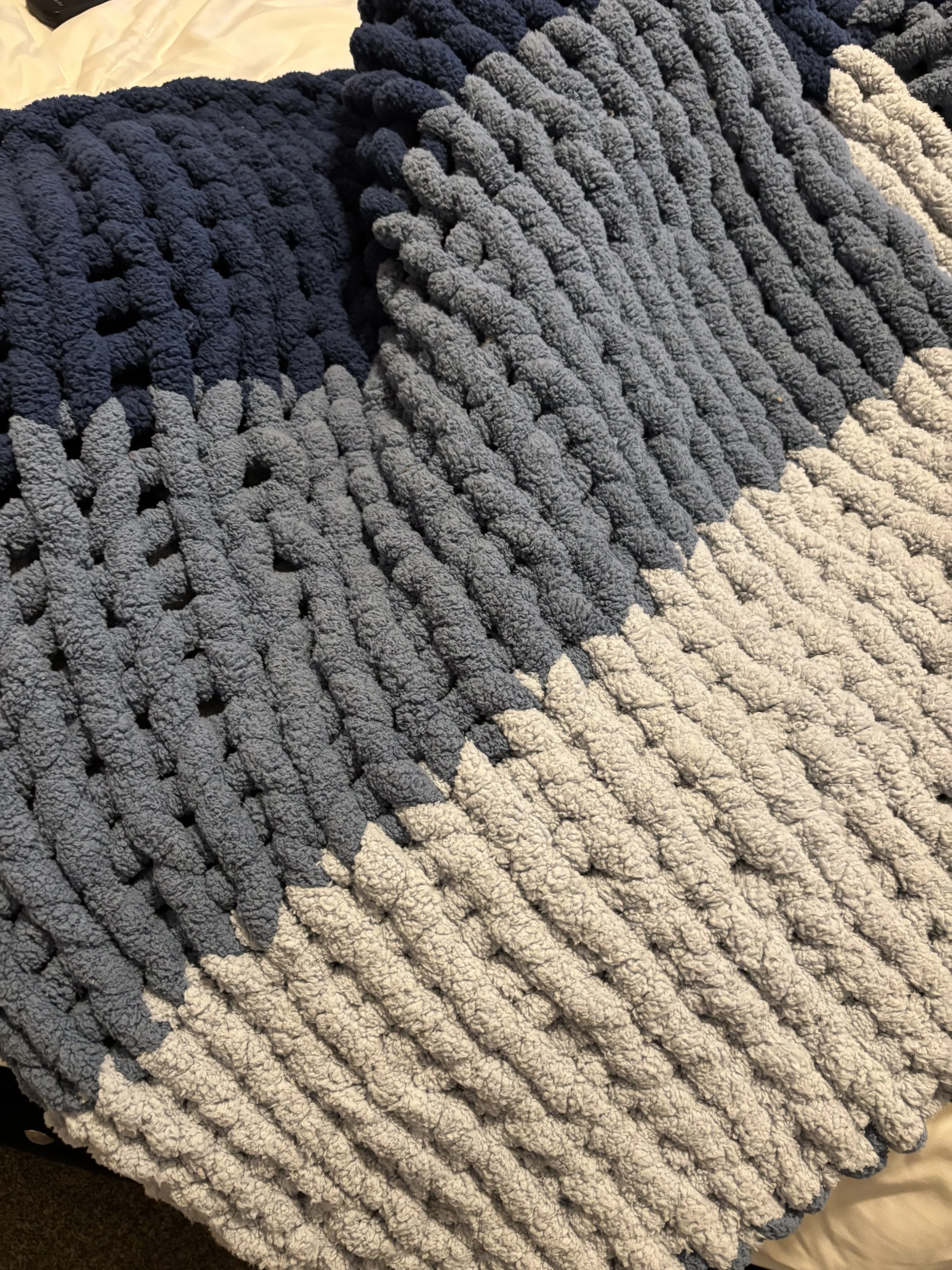 Two color knit blanket, colors dark blue and sky blue, woven together.