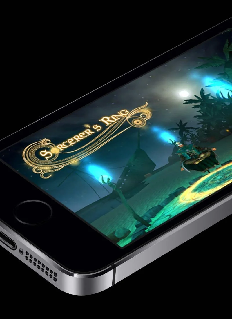 Close-up of a cellphone screen displaying the title 'Sorcerer's Ring' with a fantasy game scene, including a character casting a spell outdoors at night.