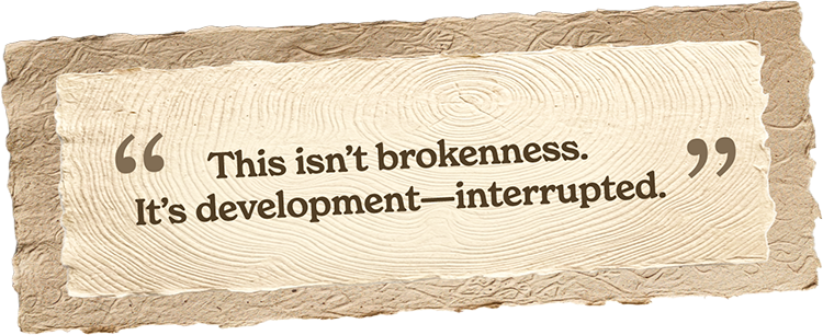A quote on a piece of torn paper that says, "This isn't brokenness. It's development—interrupted."