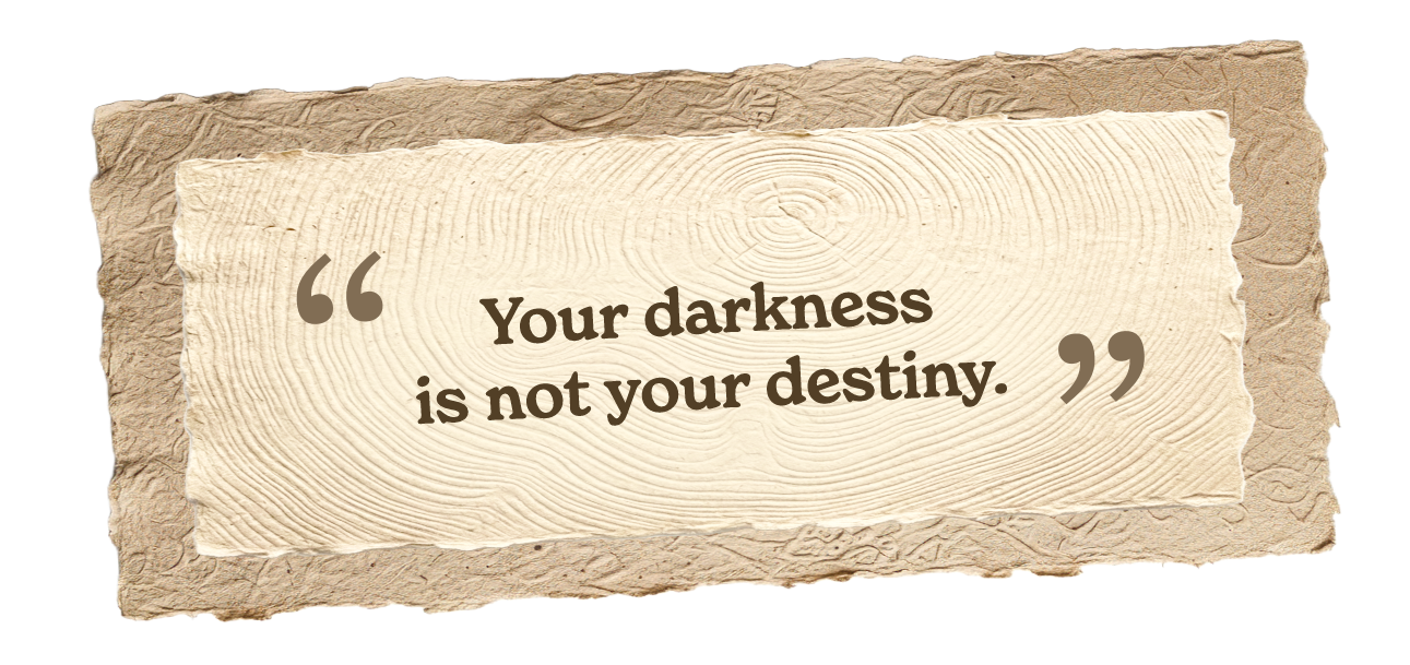 Inspirational quote on textured beige paper that reads, "Your darkness is not your destiny."
