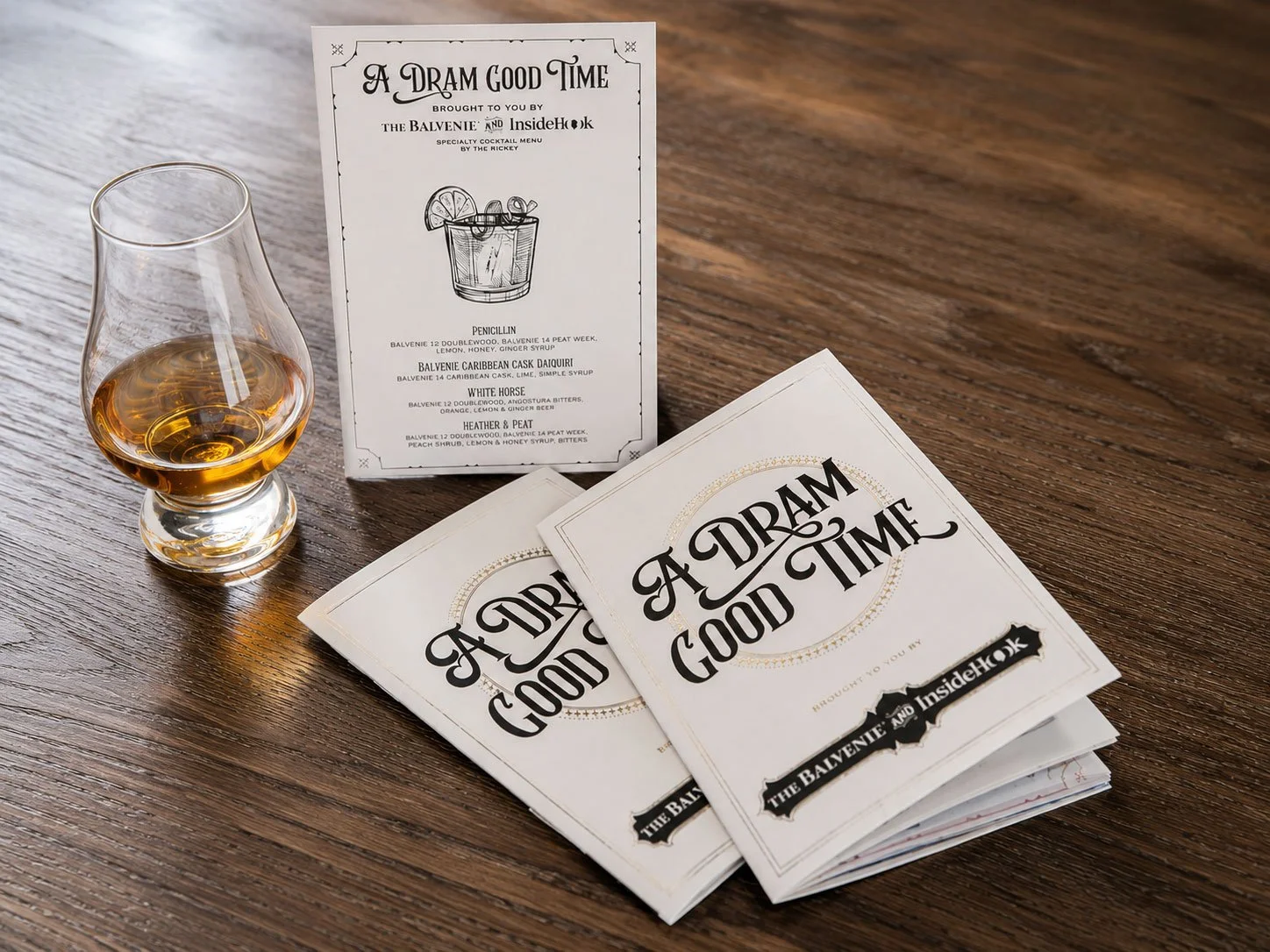 Custom event paper suite for "A Dram Good Time," a co-branded scotch tasting event by The Balvenie and InsideHook, featuring an illustrated cocktail menu card and custom tasting booklets with Victorian-inspired typography and original pen-and-ink ill